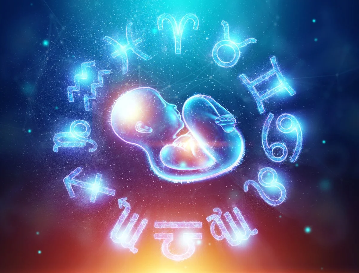 Digital illustration of a fetus surrounded by glowing zodiac signs against a starry background.
