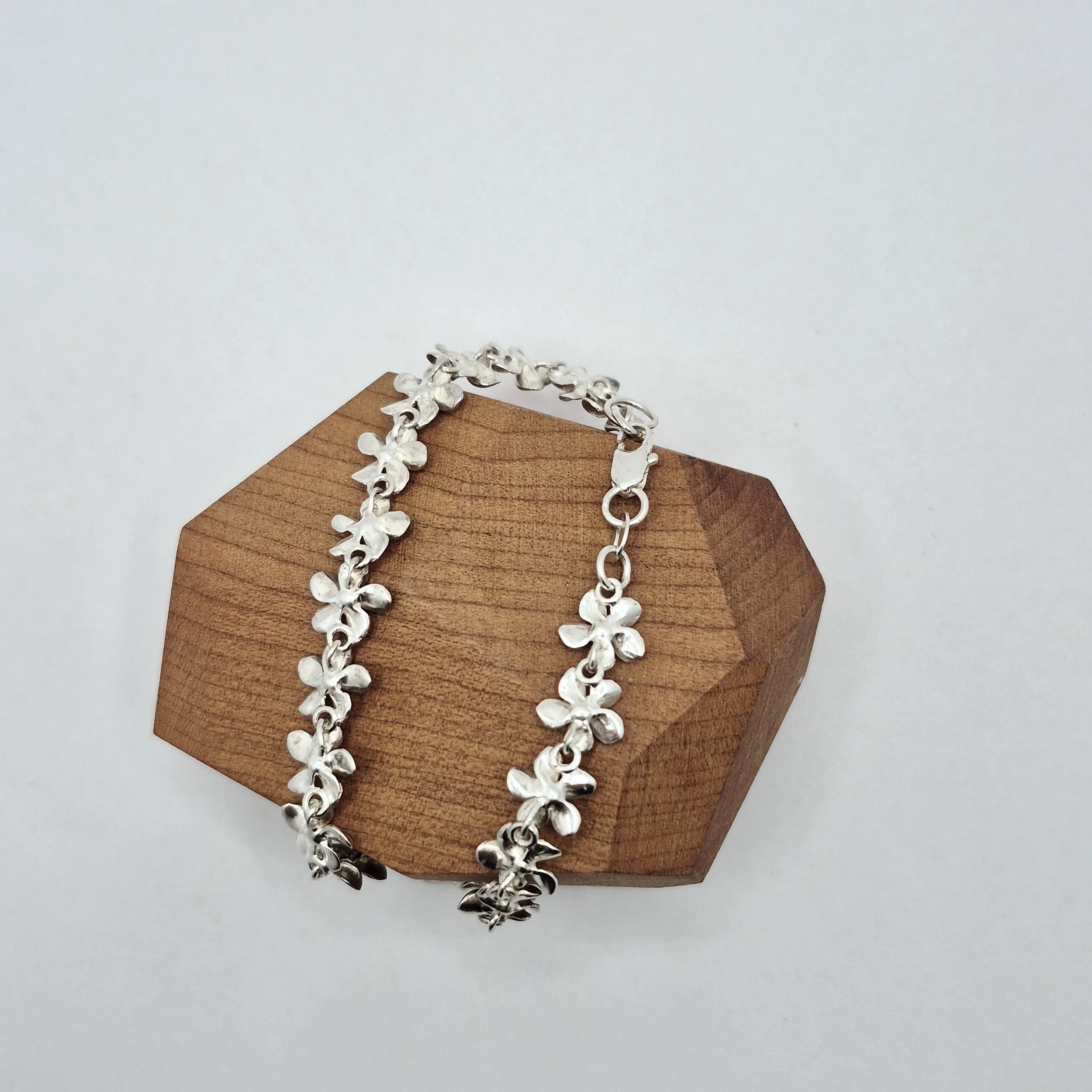 3️⃣ Dainty silver flower bracelet on display – romantic jewelry style