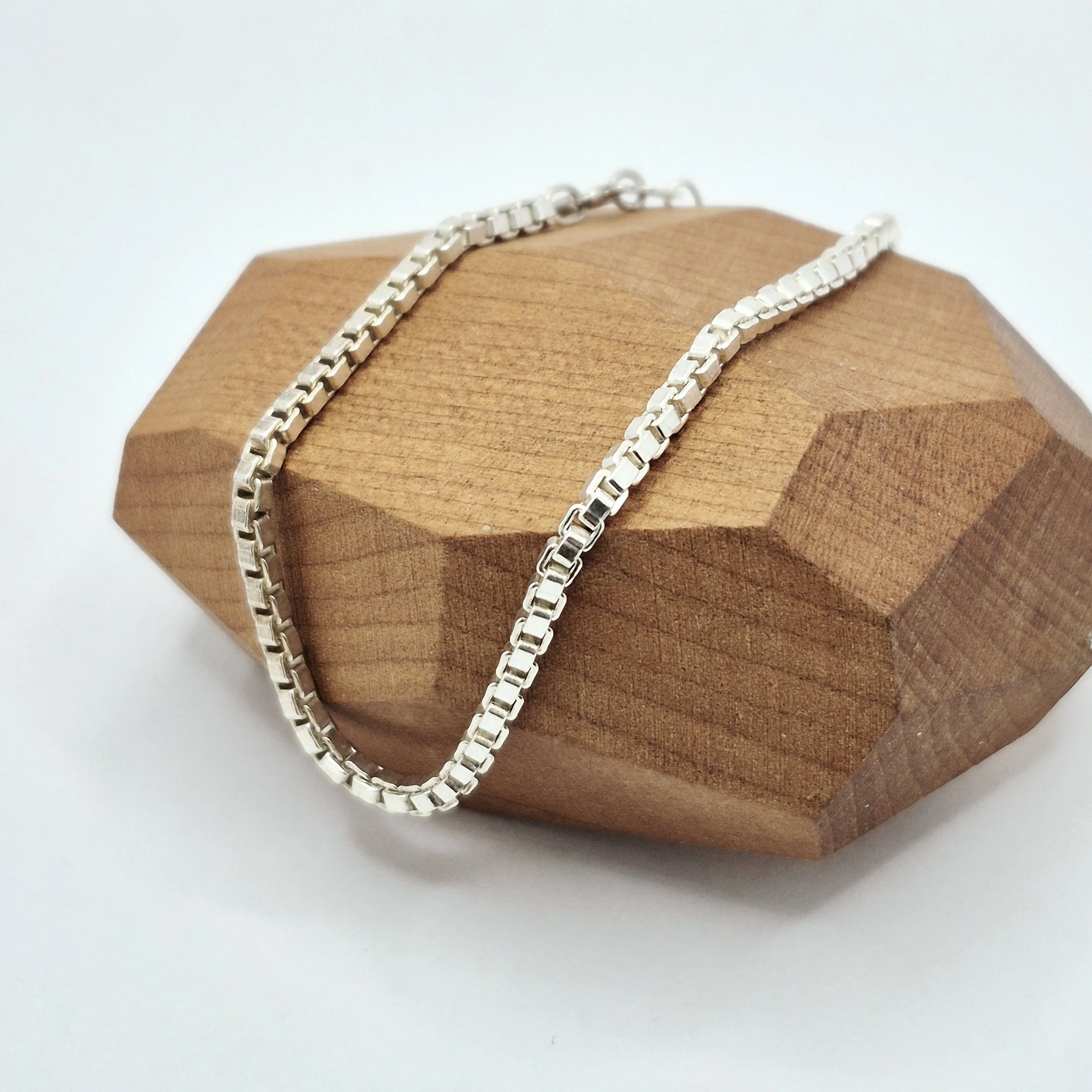 925 silver bracelet with geometric box links, displayed on wood jewelry stand