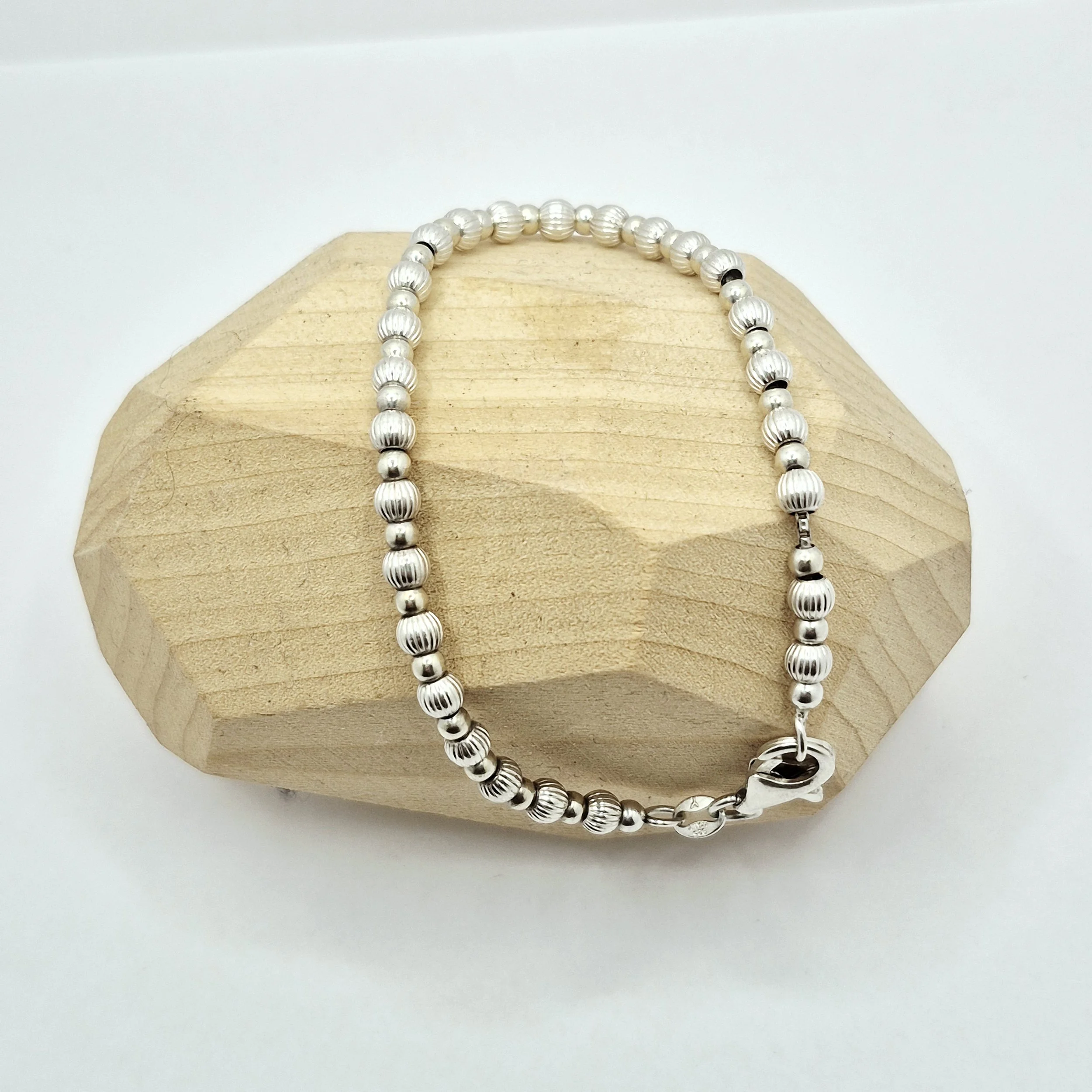925 silver bracelet featuring alternating smooth and ribbed beads on light wood display