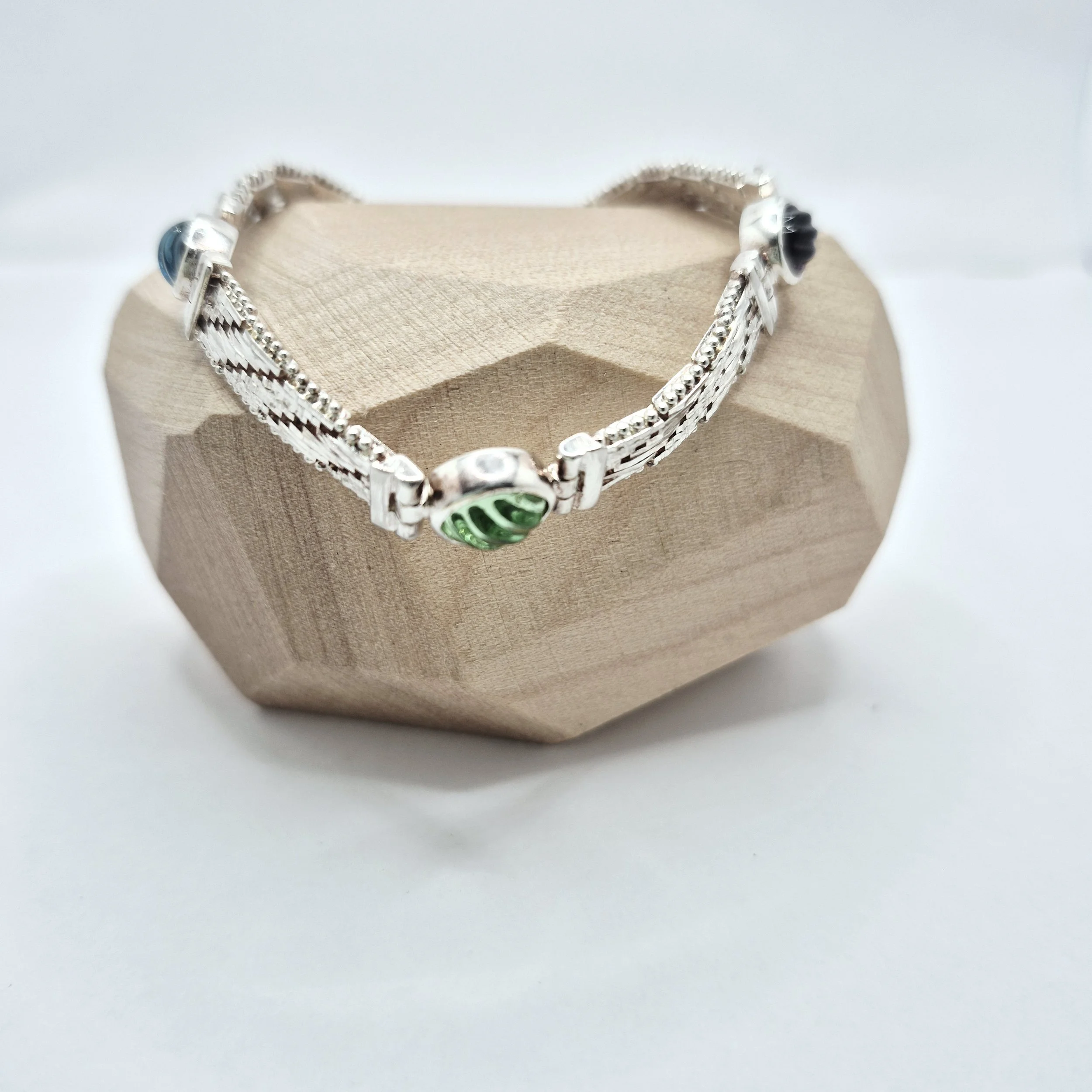 Close-up of handcrafted silver bracelet with vibrant glass embellishments