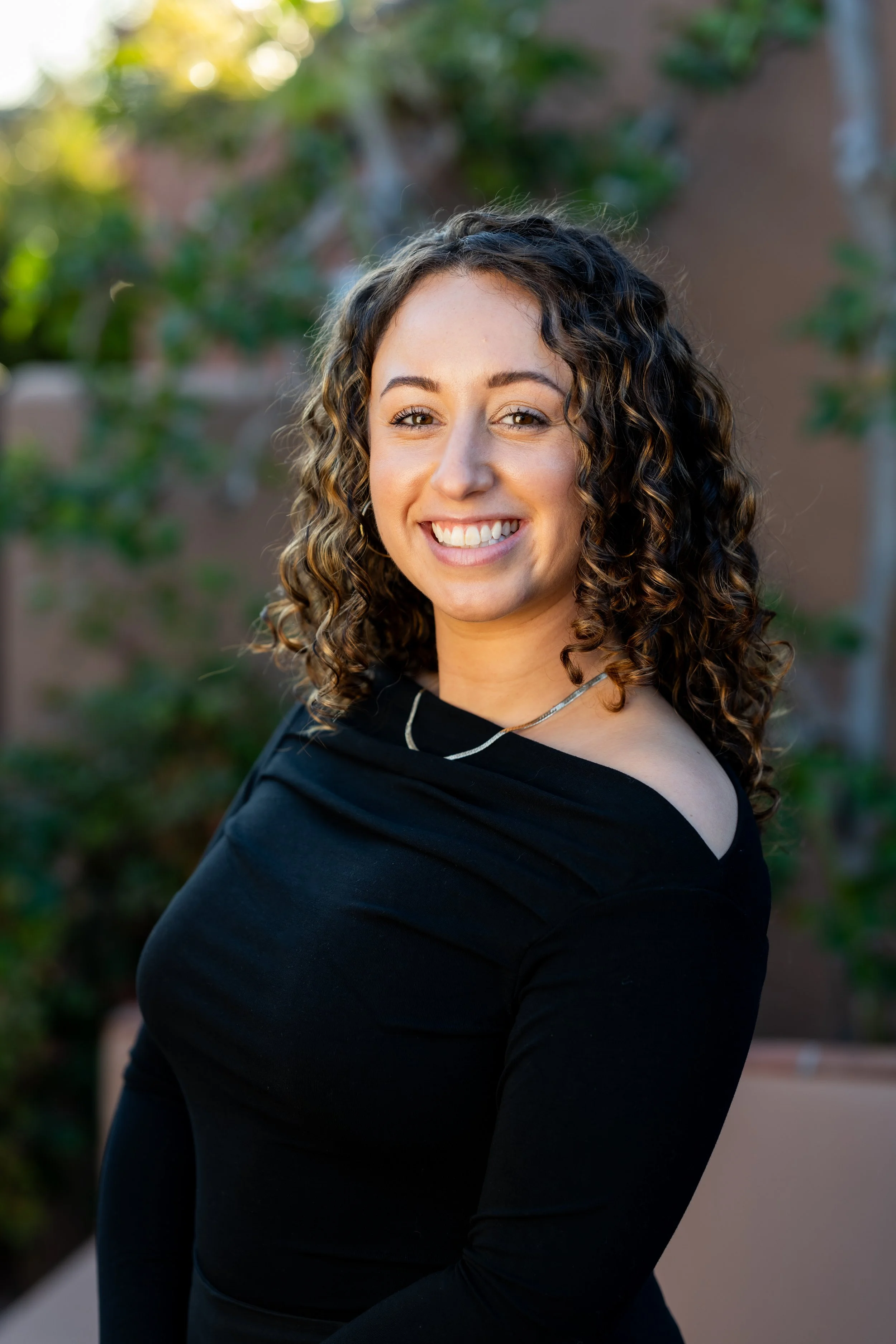 Emily Harris smiling in a black off shoulder top
