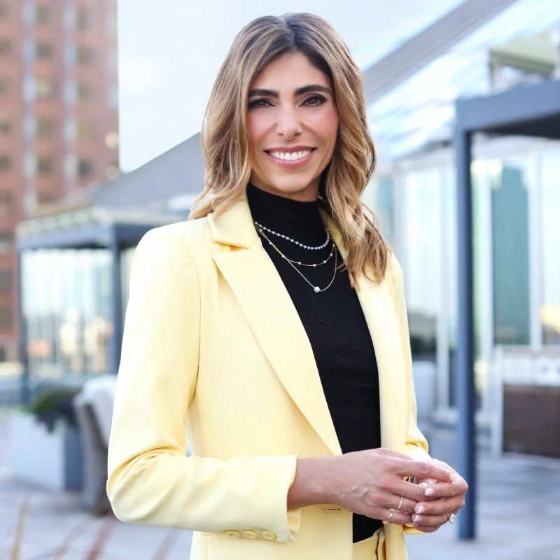 Junilla Sledziewski standing downtown in yellow blazer
