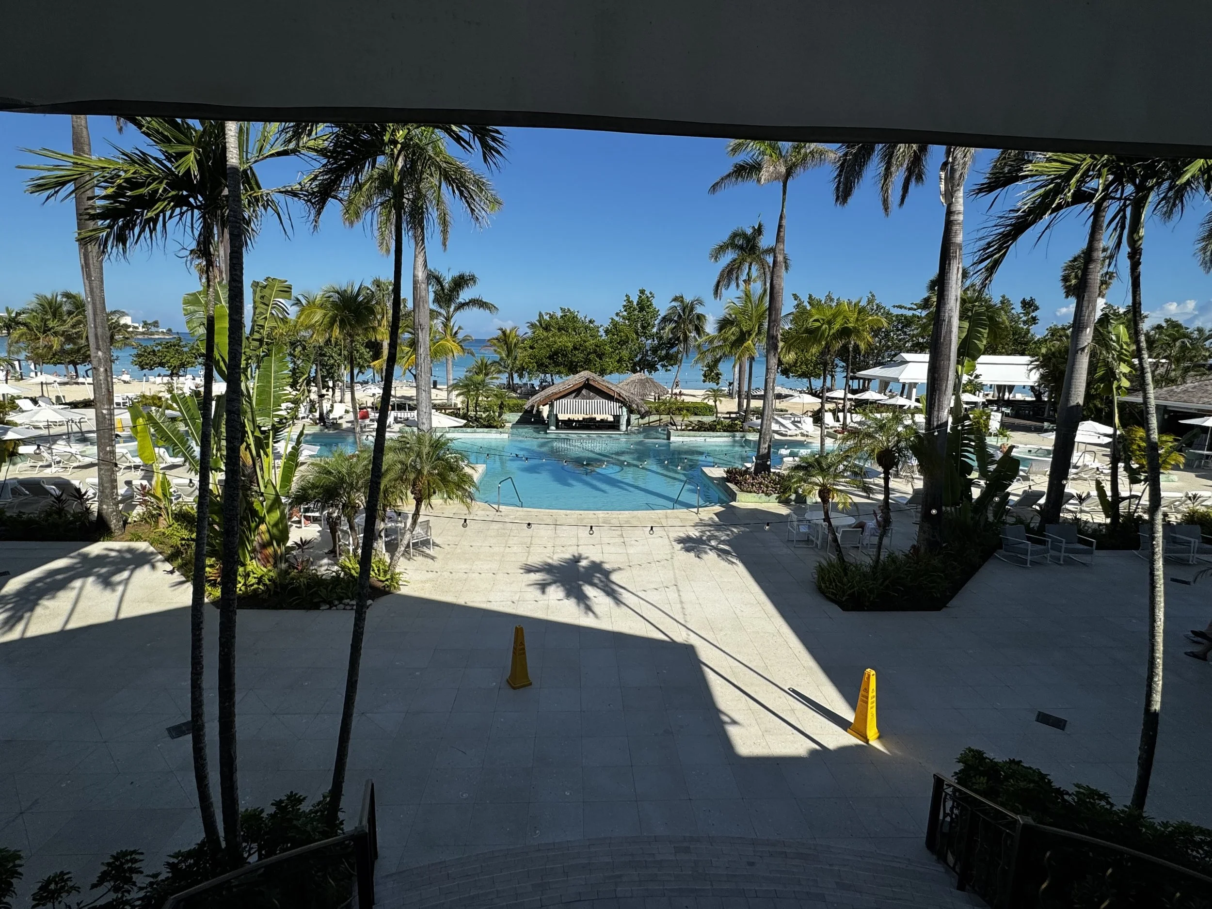 Overlooking the pool, tropical palm trees, and ocean at Couples Negril in Jamaica from the resort check-in area