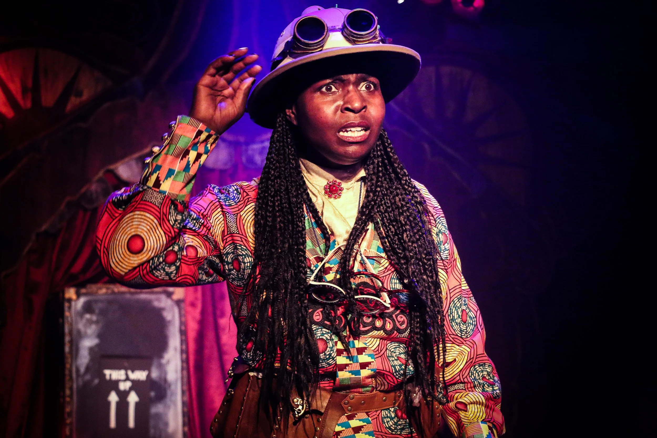 Actor performing in Goosebumps Kids, wearing a colourful costume and explorer hat with goggles during a stage scene.