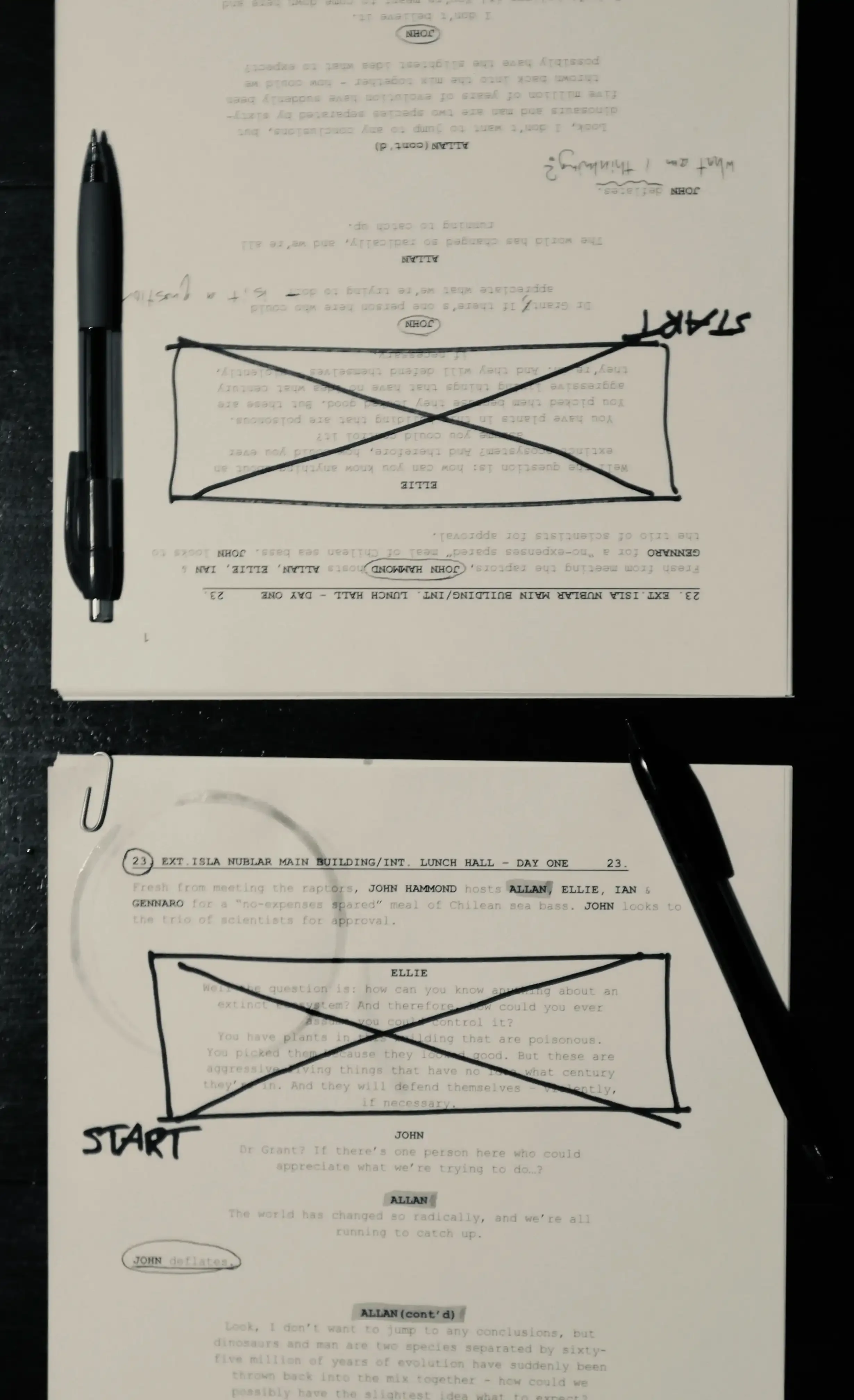 Two copies of a printed movie scene lay face up side-by-side with handwritten notes and coffee cup stains, suggesting a pair of actors has been working on this scene.