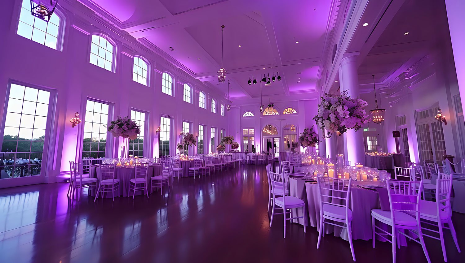 DJ Adam Subtract'em, purple uplighting in grand ballroom with tables and chairs.