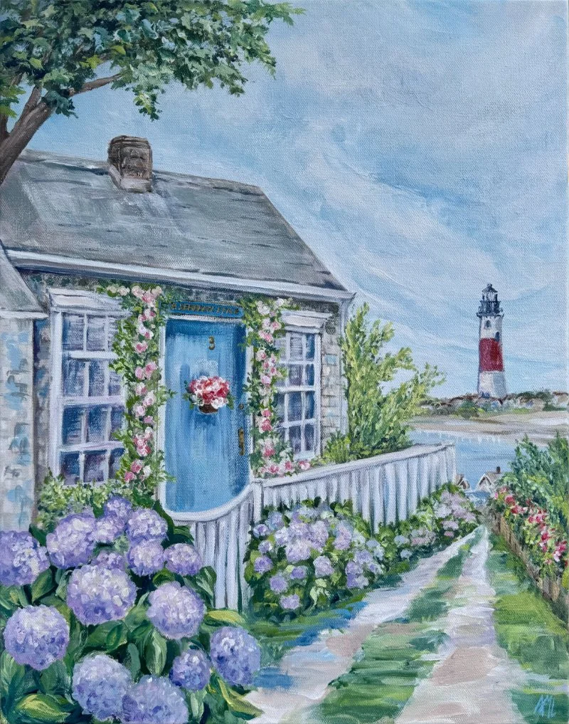 A watercolor painting of a coastal scene featuring a stone house with a blue door decorated with pink flowers, surrounded by purple hydrangeas and lush greenery. A pathway leads toward a bridge and a lighthouse in the distance under a partly cloudy sky.