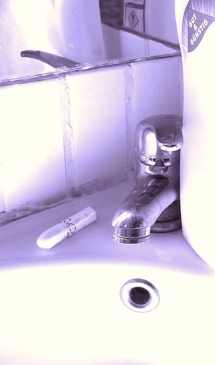 Foto von Wasserhahn mit Flasche Putzmittel und Tampon.