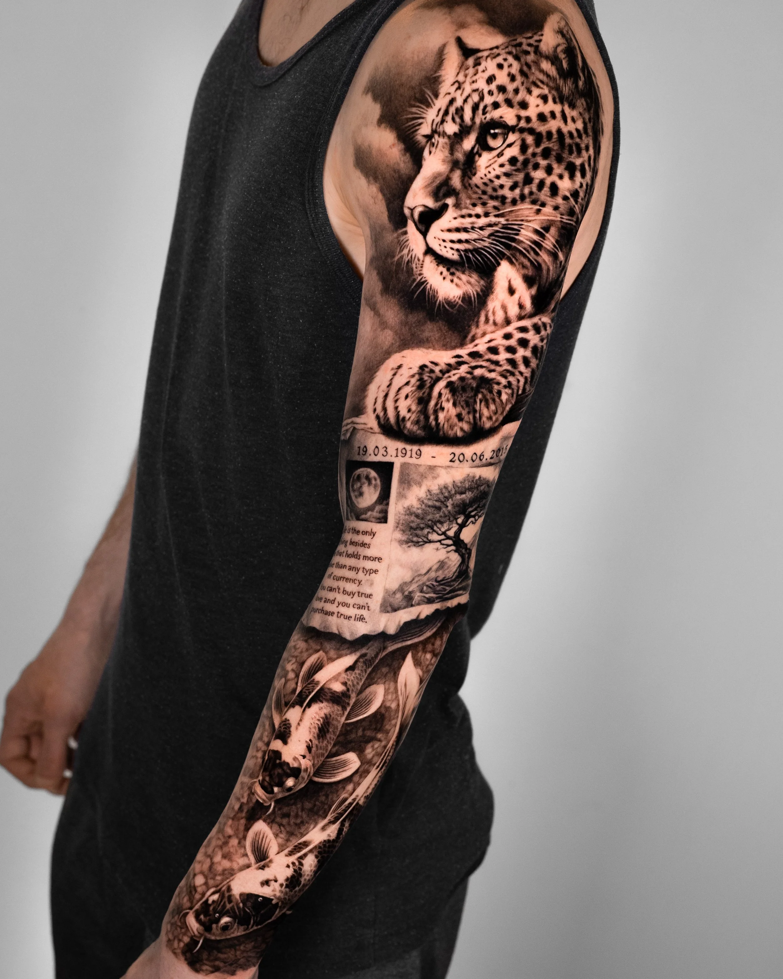 Tätowierung eines Leopardenkopfes auf dem Arm einer Person, ergänzt durch weitere Tätowierungen, darunter ein Baum und ein Mond, sowie einen Teiltext unterhalb der Motive.