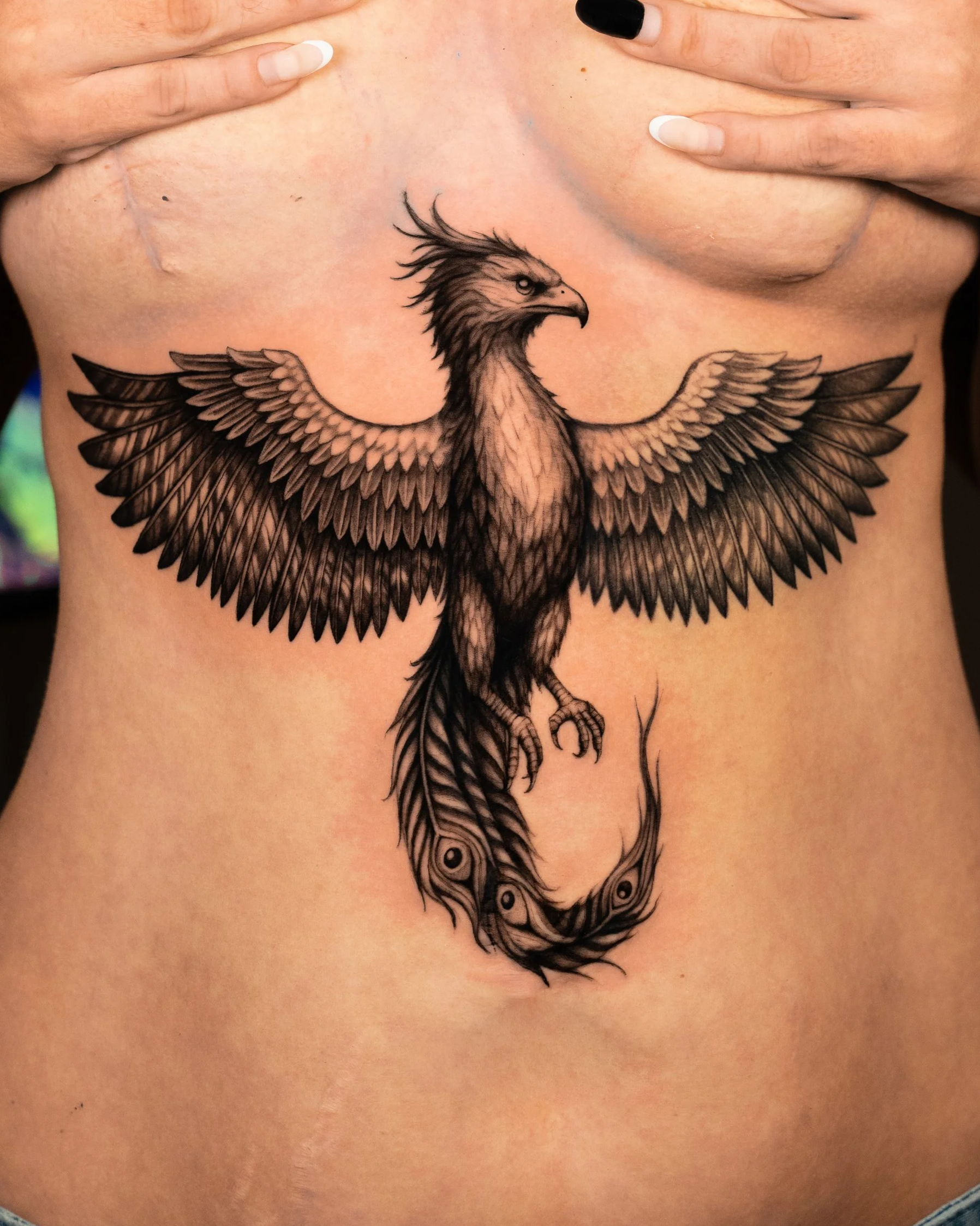 Tattoo of a detailed eagle with spread wings on a person's lower abdomen.