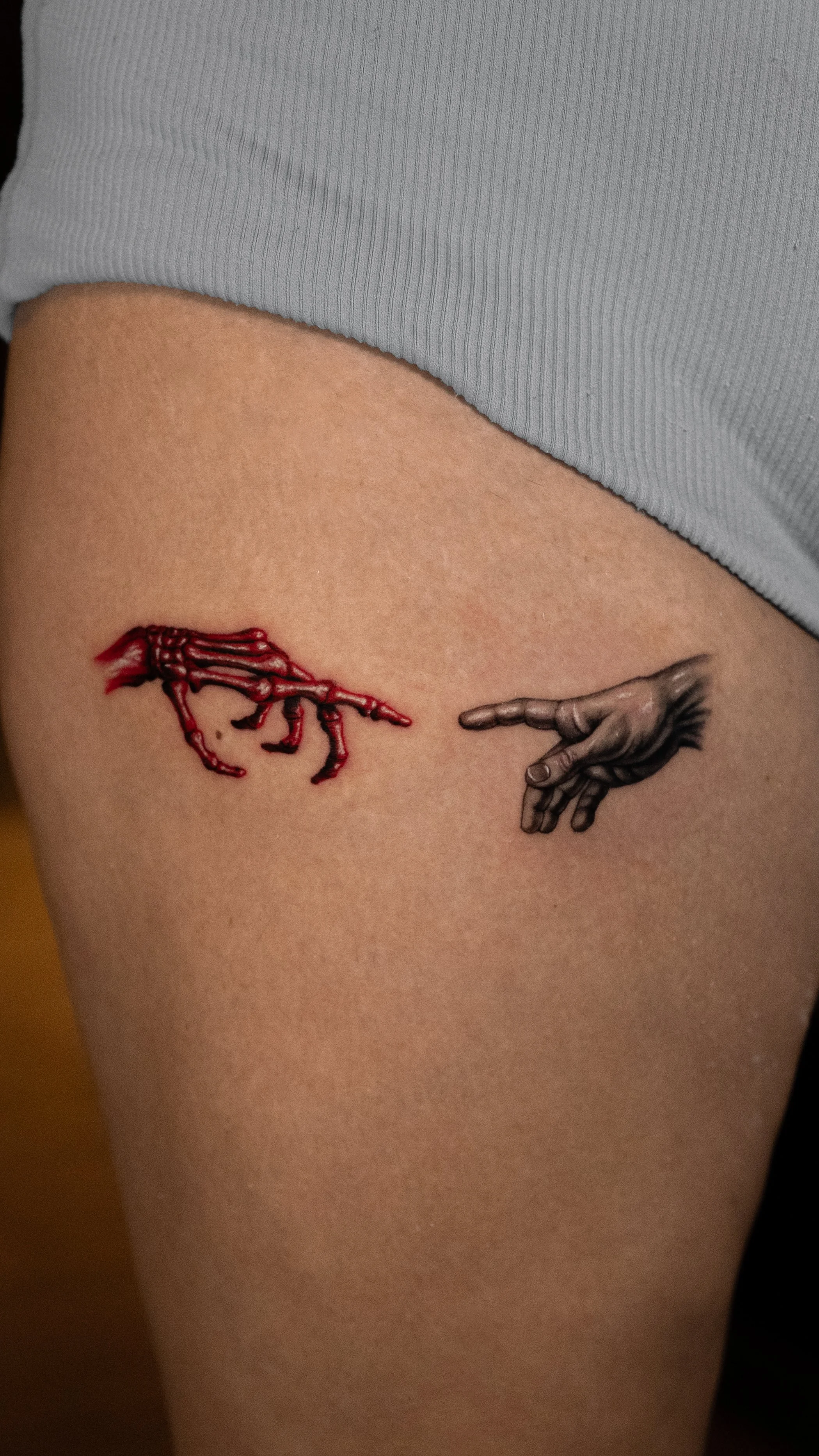 Tattoo of a red crab on the left and a black hand pointing on the right