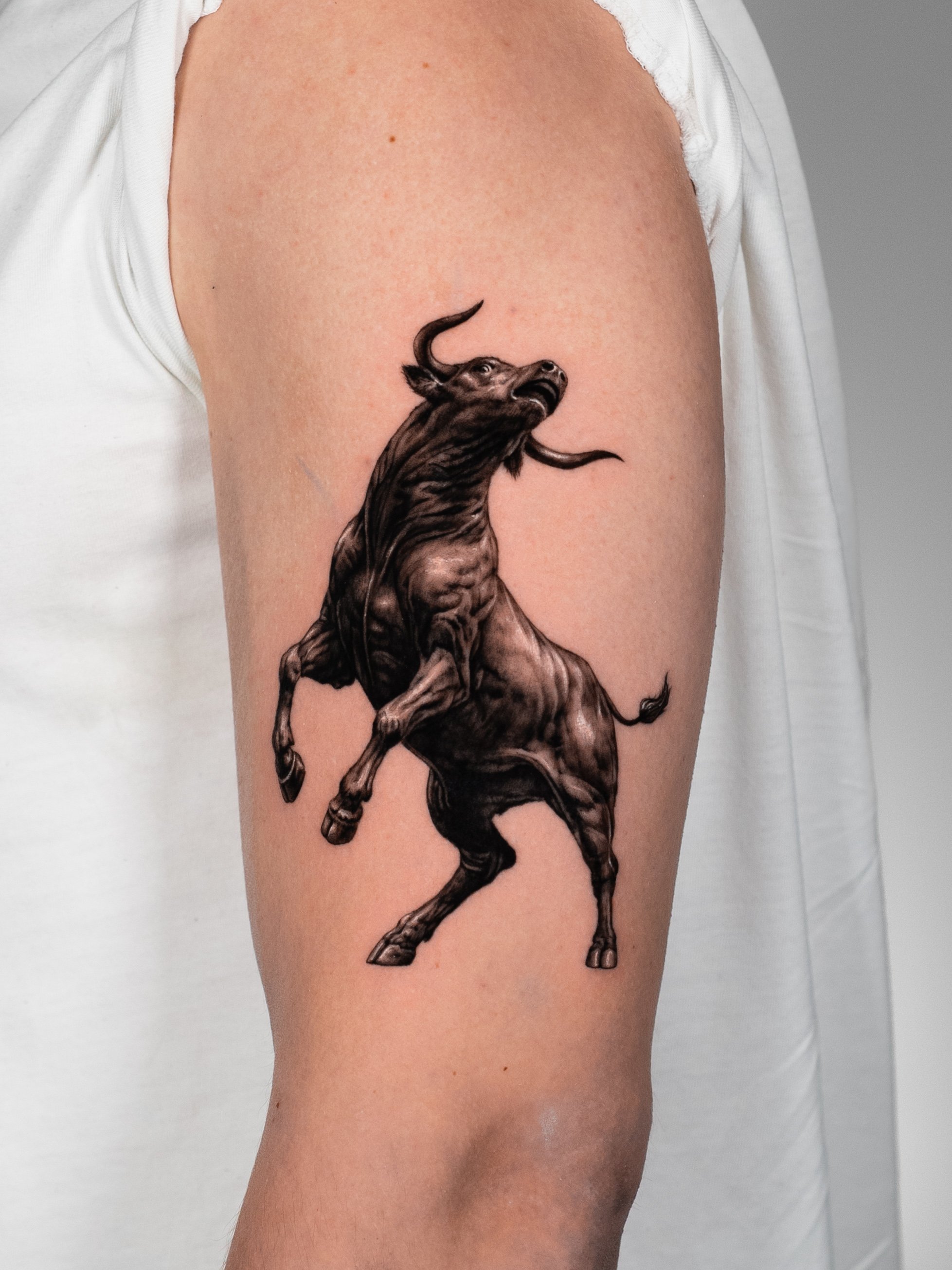 Tattoo of a black and gray horse on a person's upper arm