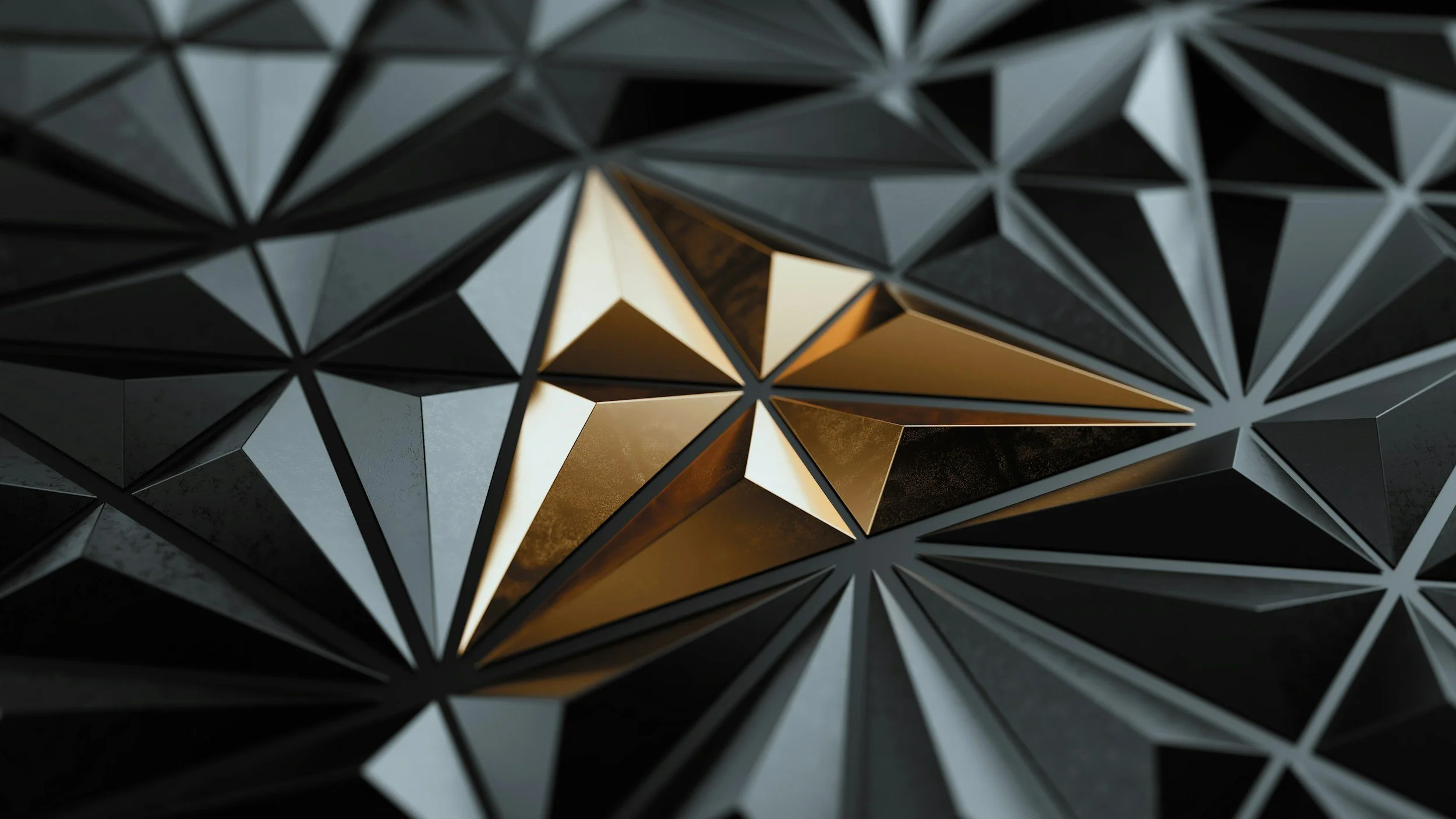 Close-up of a geometric, metallic 3D star shape with black and gold triangular facets.