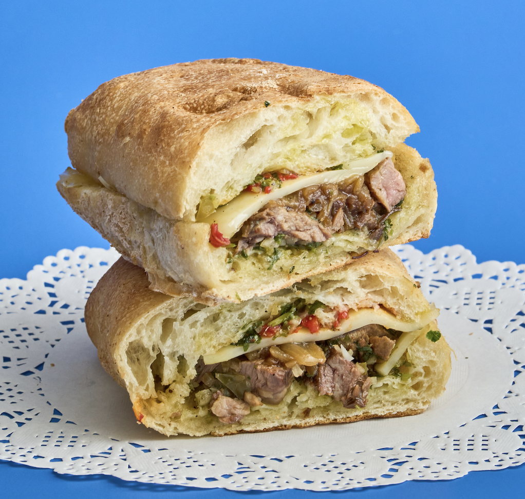 Pip's Chimichurri Steak Sandwich on pressed demi-ciabatta with seared steak, house chimichurri, roasted peppers, and caramelized onions at Pip's Café & Provisions in Greenport, North Fork, NY.