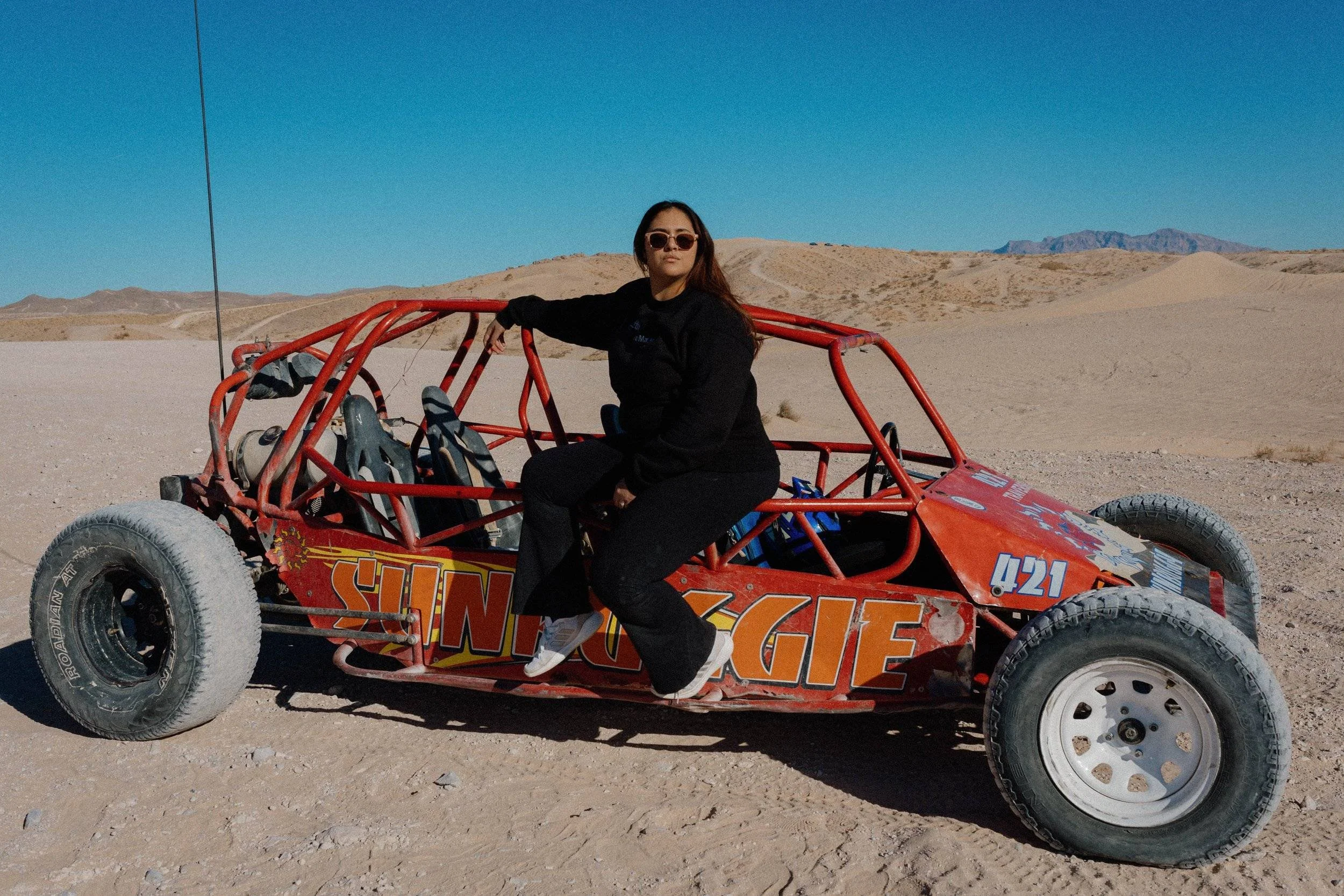 woman sitting on a dune dune buggy in the Las Vegas desert.