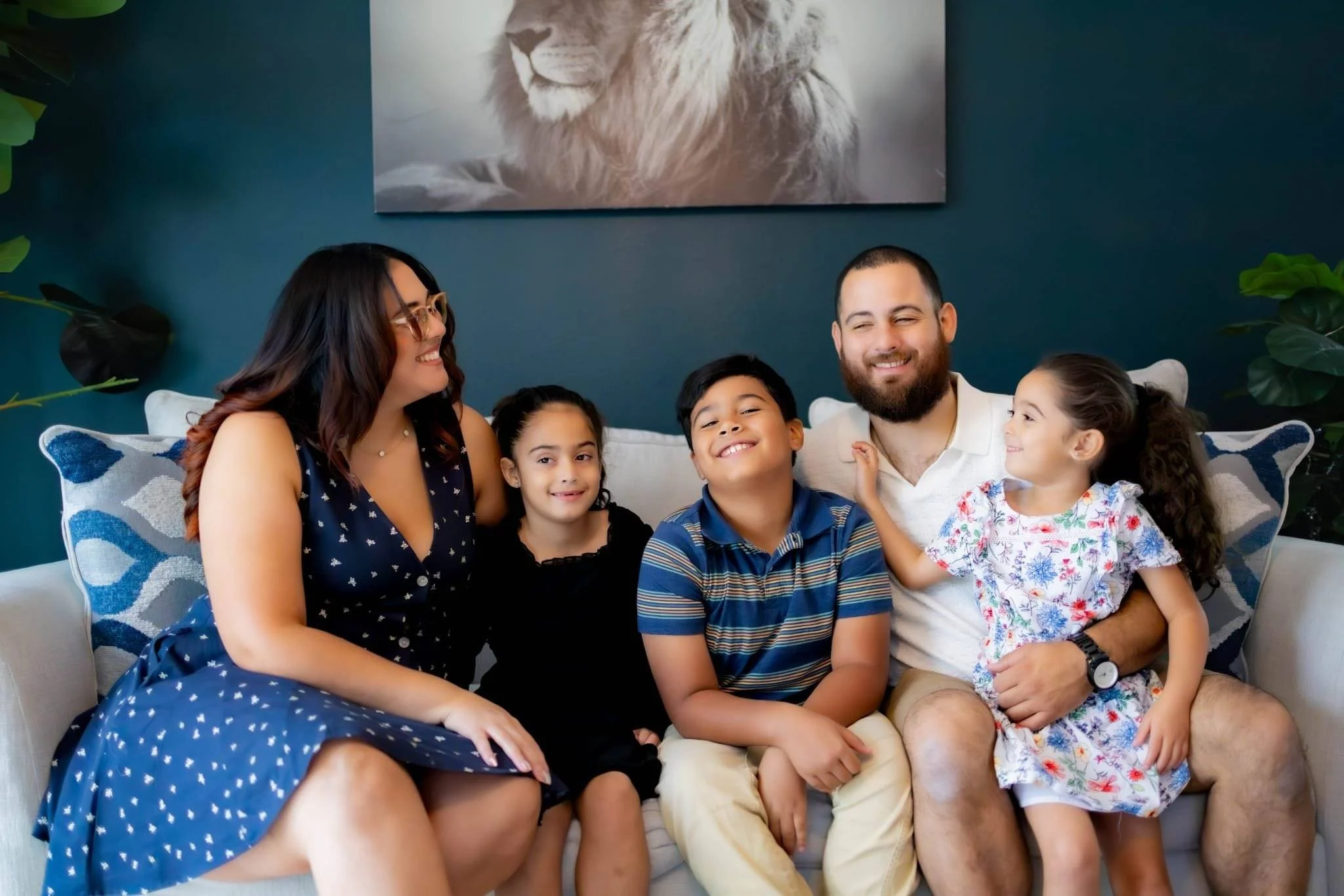 Family sitting in a living room smilng at each other.