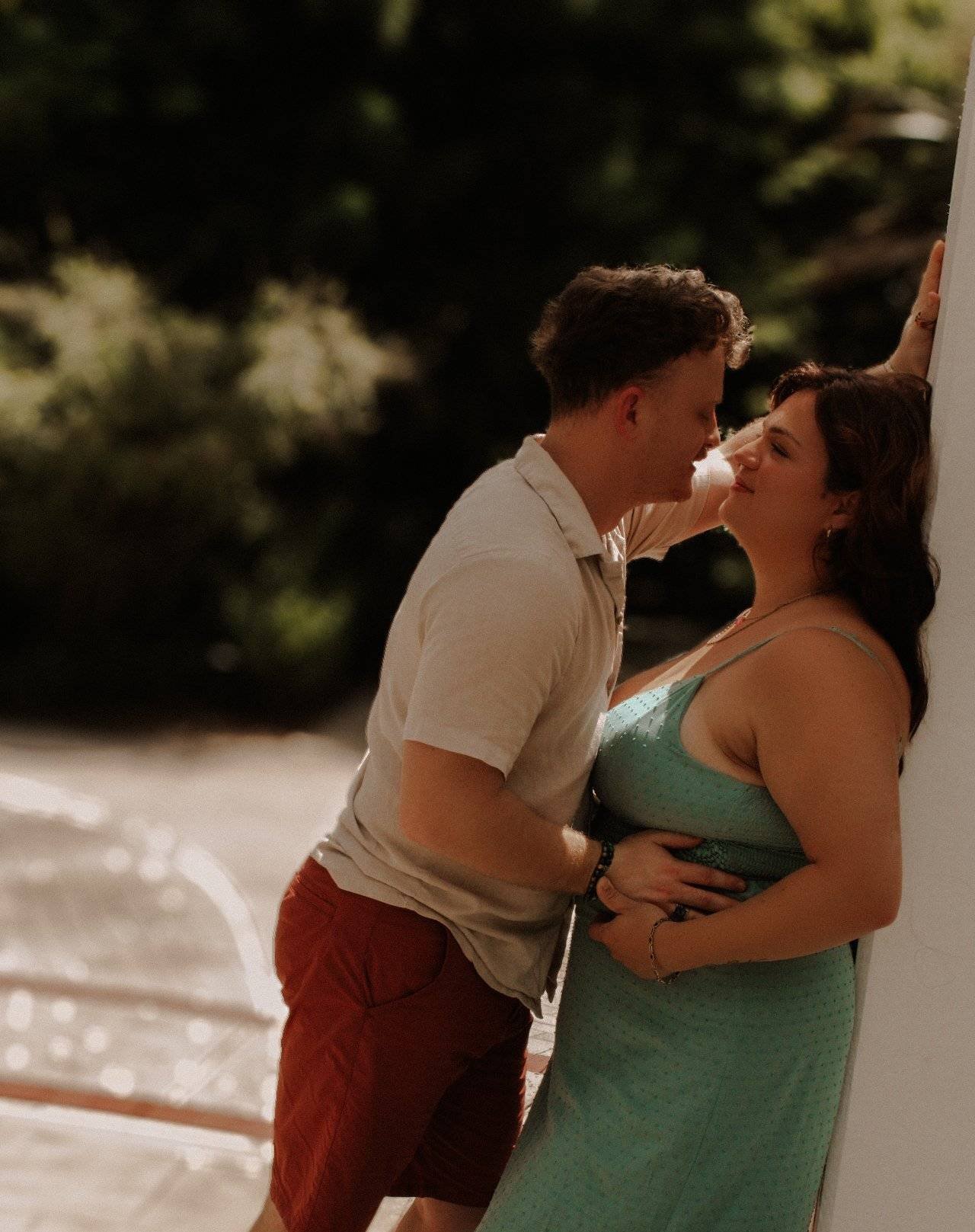 Man leaning over a woman as they stare into each other's eyes.