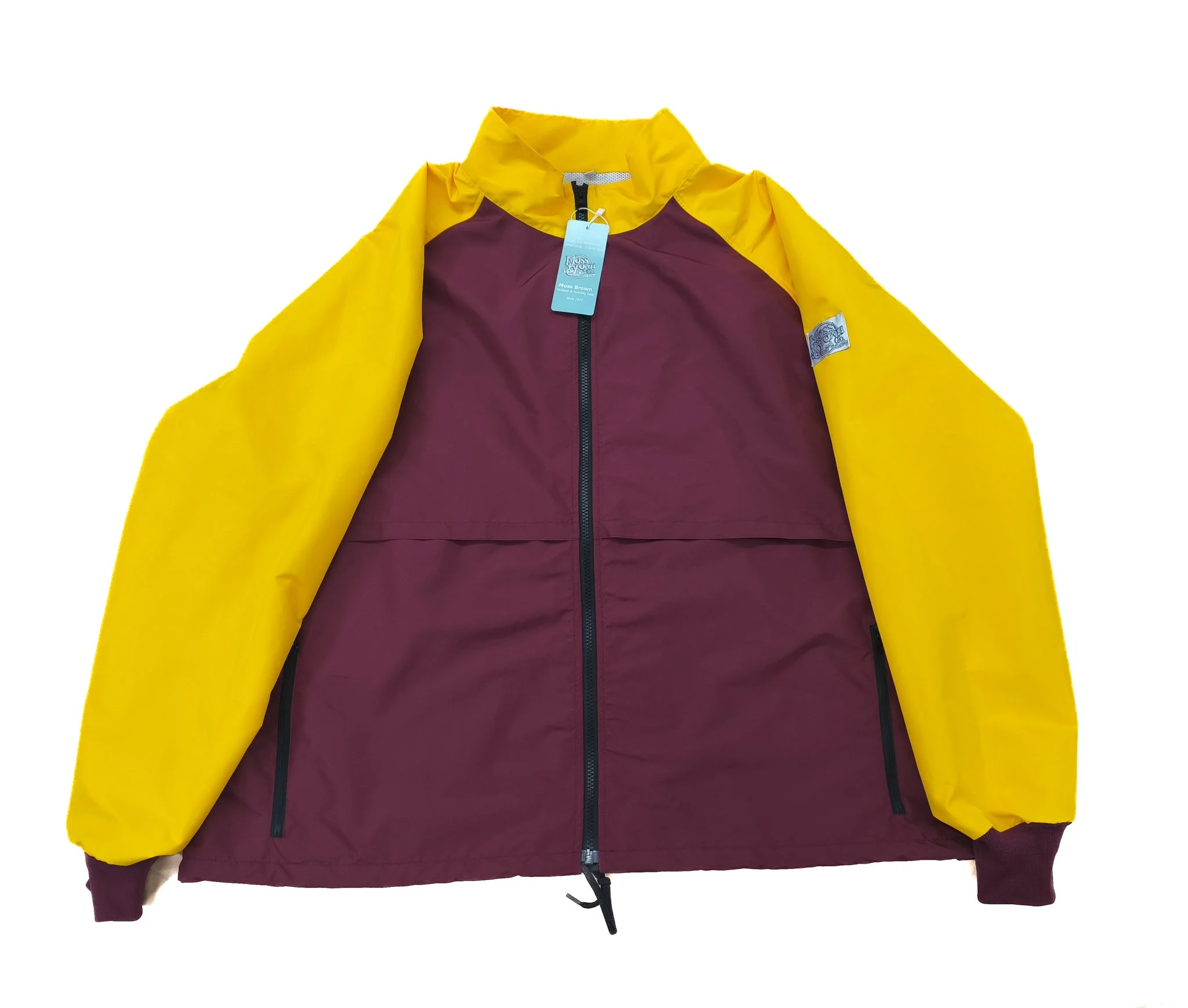 A two-tone yellow and maroon waterproof jacket with a tag hanging from the collar, suitable for outdoor activities.