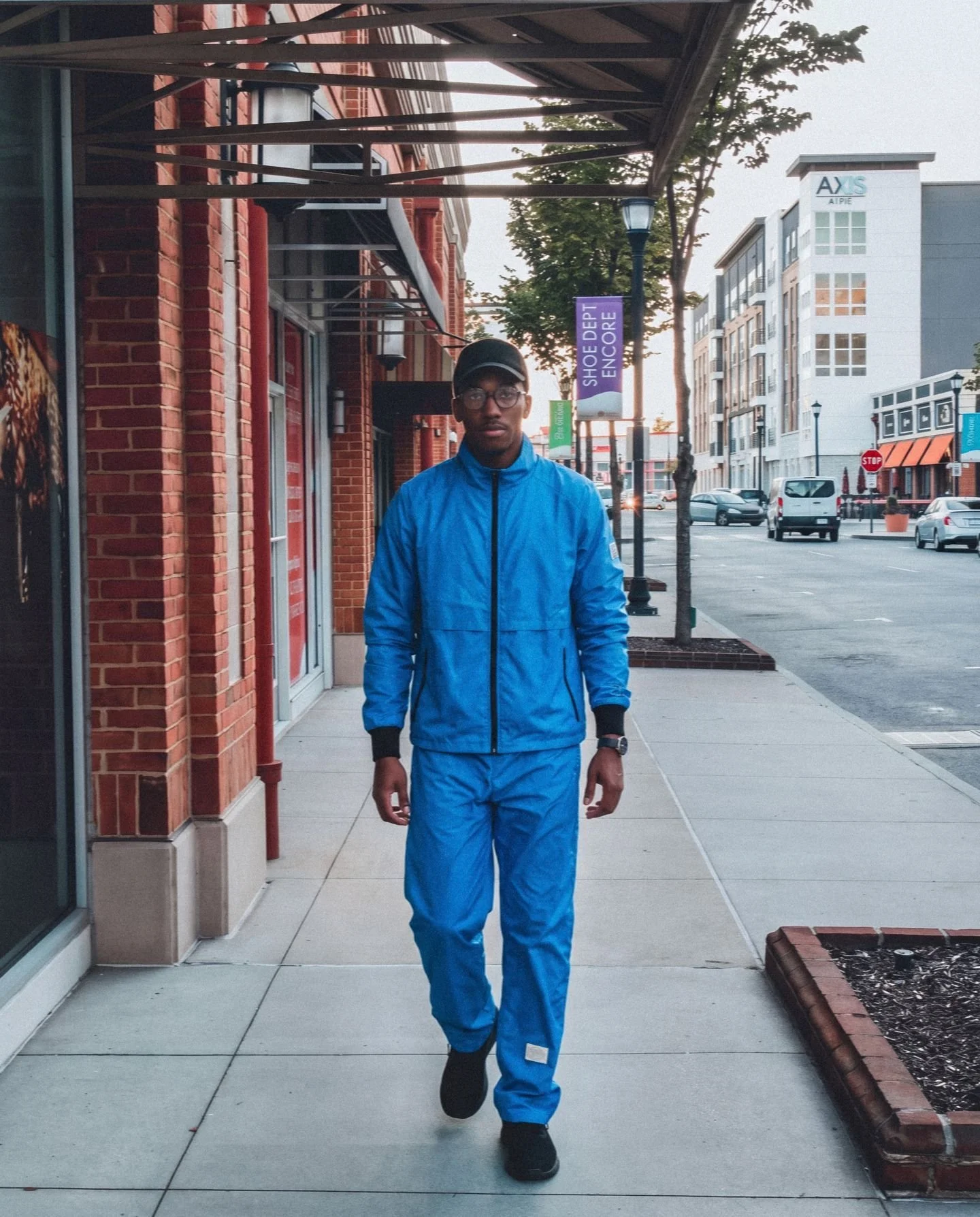 Model wearing the lightweight, water-resistant Brilliant Blue 10-Miler matching jacket and pants set outdoors, showcasing the full casual lifestyle fit.