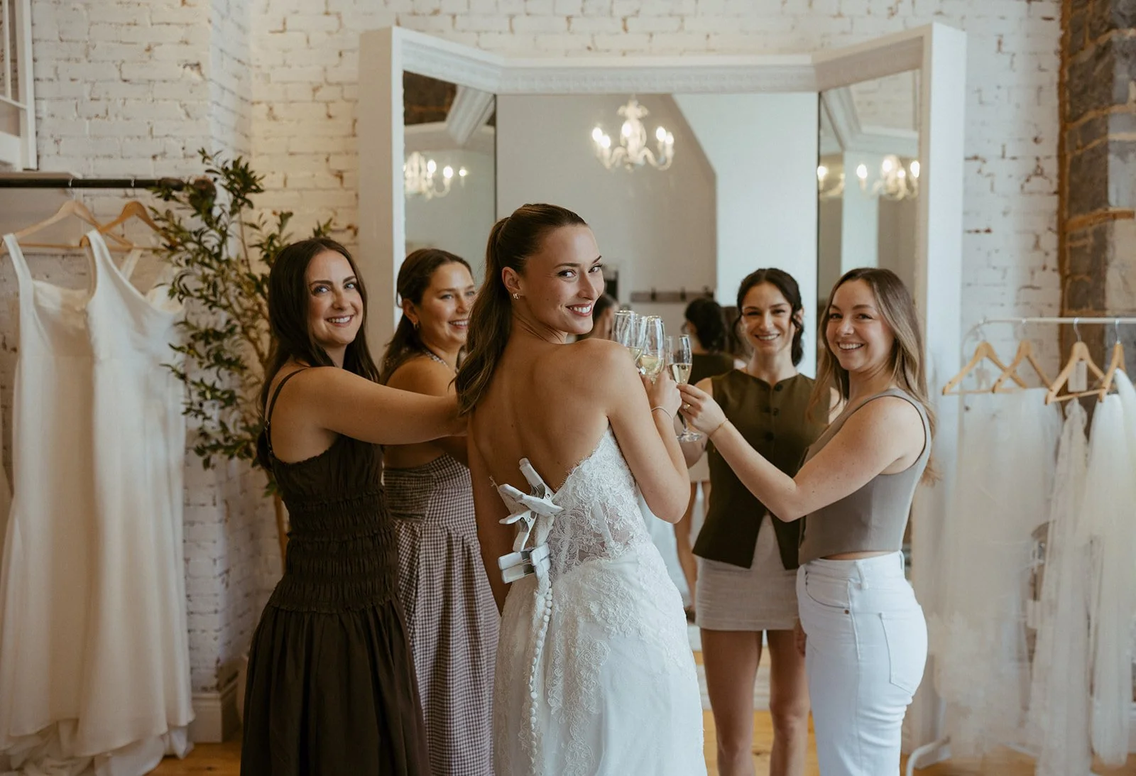Person pouring champagne into flutes on a white surface.