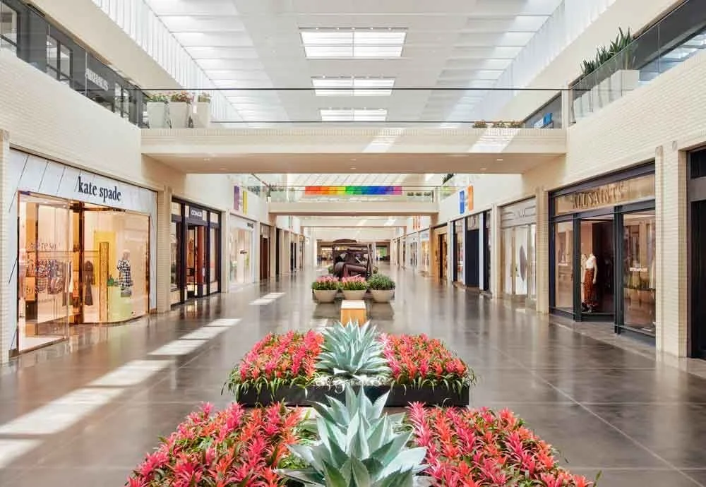 Interior corridor of NorthPark Center shopping mall in Dallas with storefronts and floral display