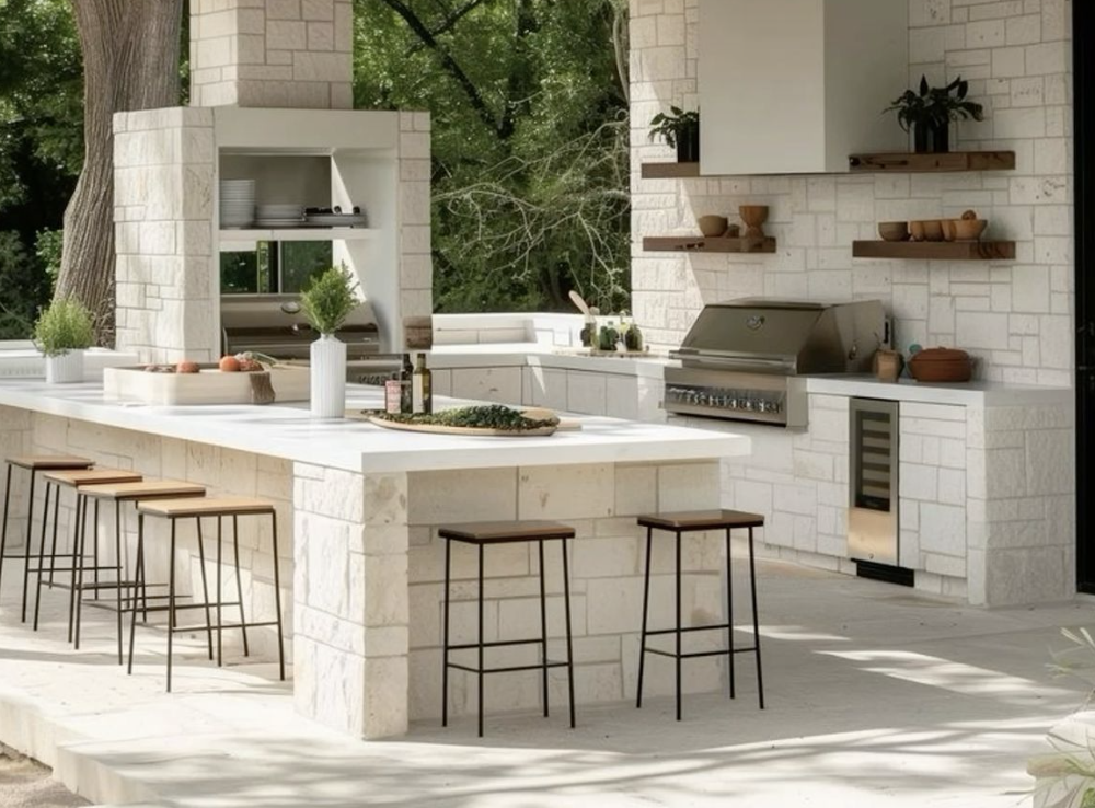 white stone outdoor kitchen covered with grill, storage and decoration