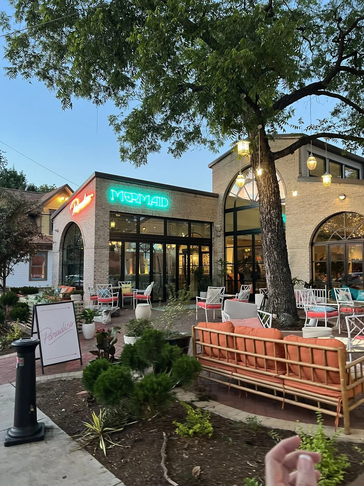 Paradiso restaurant patio with string lights and outdoor seating in Dallas at dusk