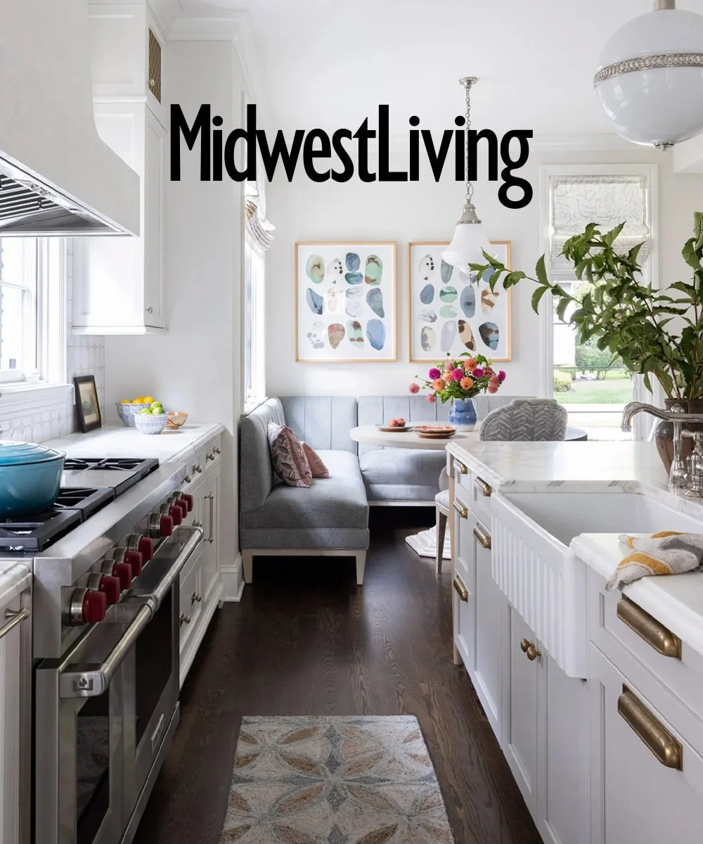 Midwest Living March 2026 feature on a storybook Michigan home designed by Ramsay Nye Interior Design, showing the kitchen with white cabinetry, a breakfast nook and colorful artwork.