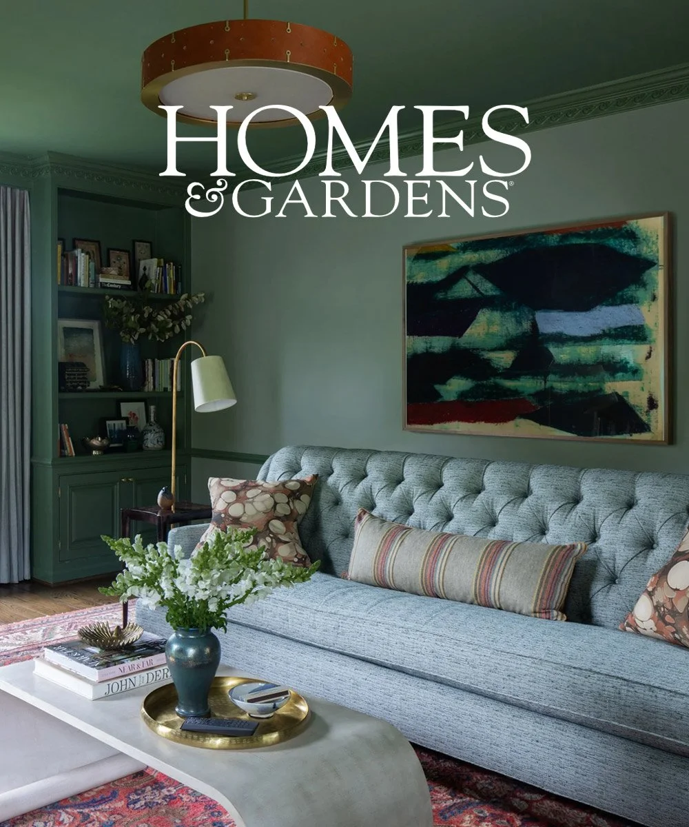 Homes &amp; Gardens January 2025 feature on a colorful Michigan ranch designed by Ramsay Nye Interior Design, showing a green library with a tufted sofa, built-ins, and original art.