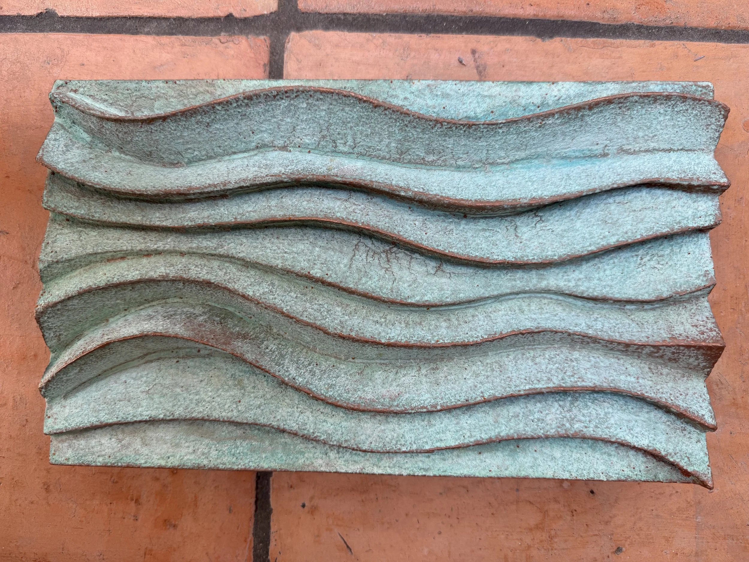 Close view of the Verdigris Ripple Wave Wall Sculpture showing the layered wave crests in green patina