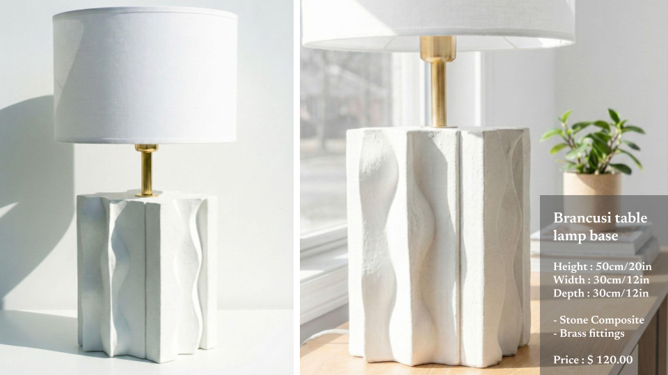 A white table lamp with a stone composite base and brass fittings, featuring a wavy textured design, placed on a white surface near a window, with a small potted plant in the background.
