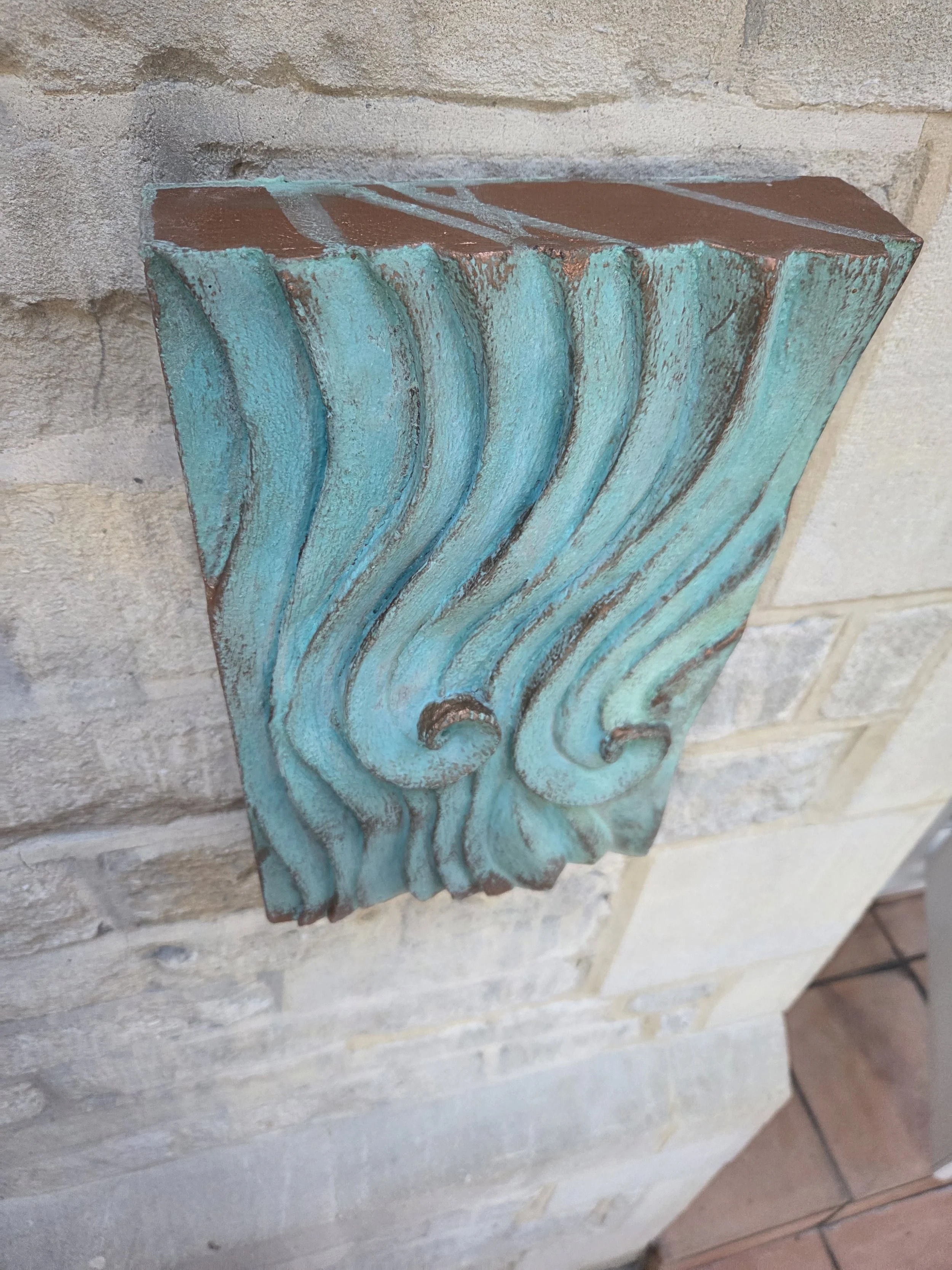 Close view of the verdigris Wave Relief Wall Sculpture showing the turquoise patina on the carved crests