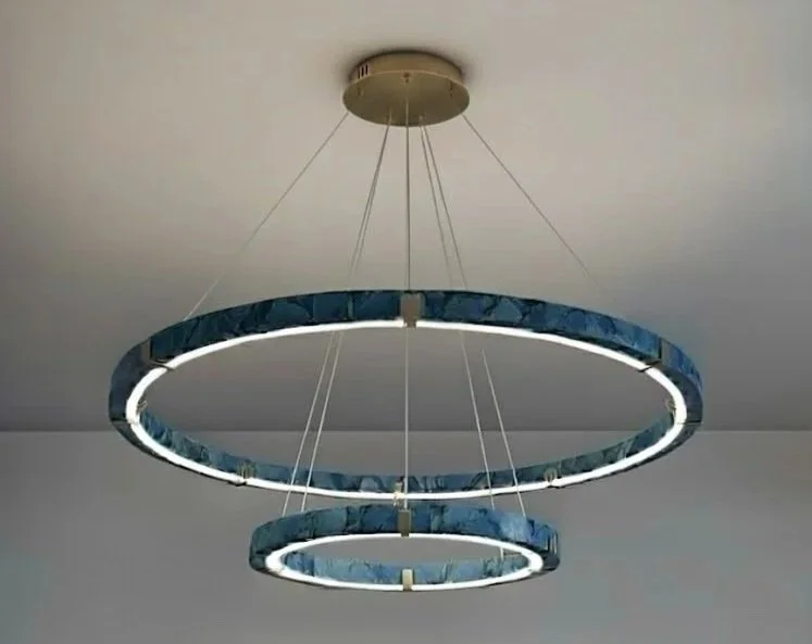 Modern circular LED chandelier with three interconnected rings hanging from the ceiling by wires.