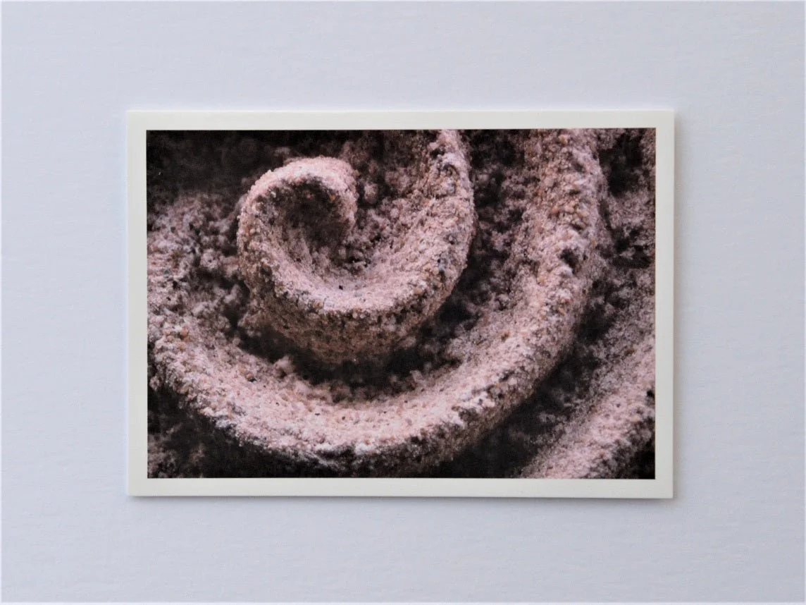 Raked Water Sculpture greetings card, a photograph of the carved raked spiral relief in pink stone light