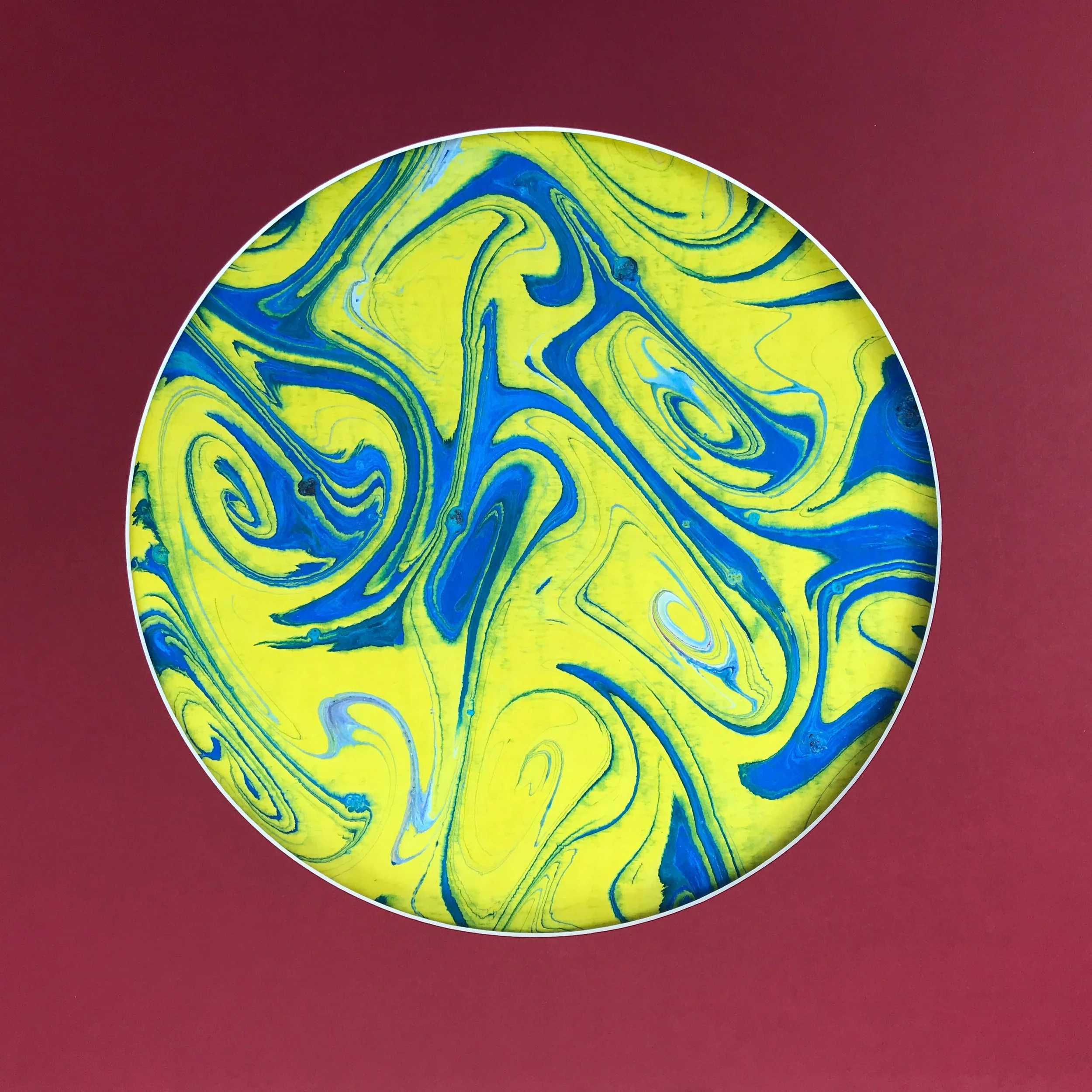 Yellow Swirl Marbled Moon print, the yellow and blue swirls shown against a deep red ground