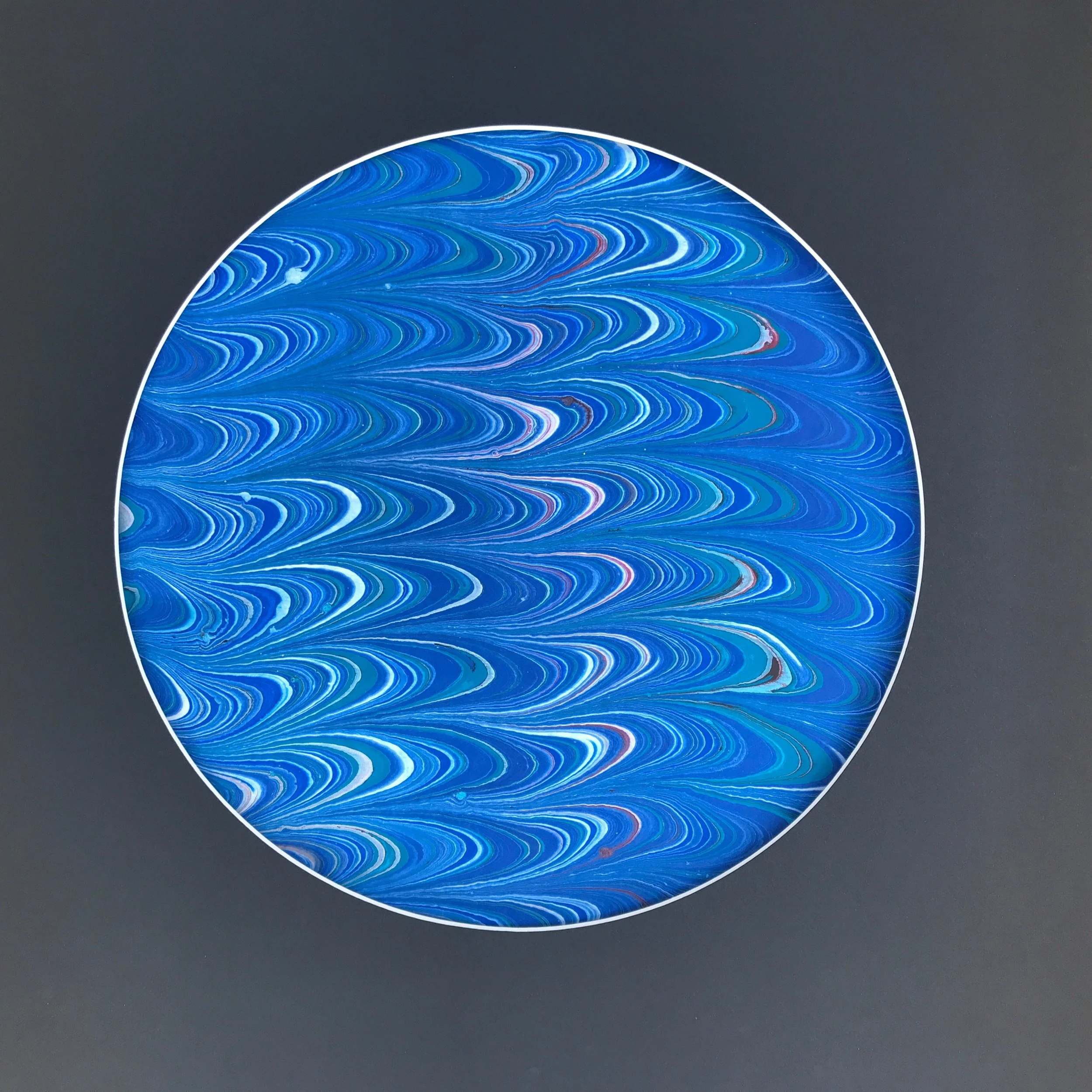 Blue River Marbled Moon print, a circular disc of finely combed blue marbling on a grey ground