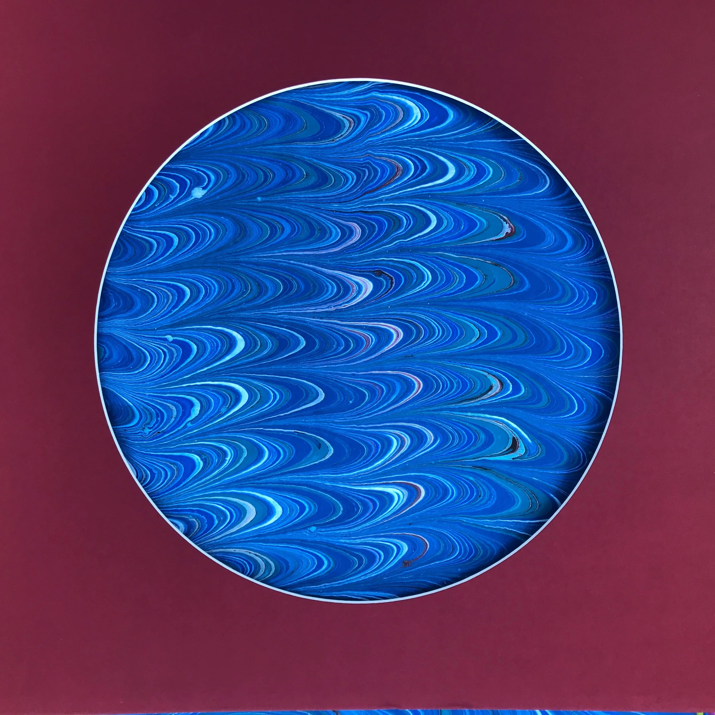 Blue River Marbled Moon print, the combed blue marbling shown against a deep red ground