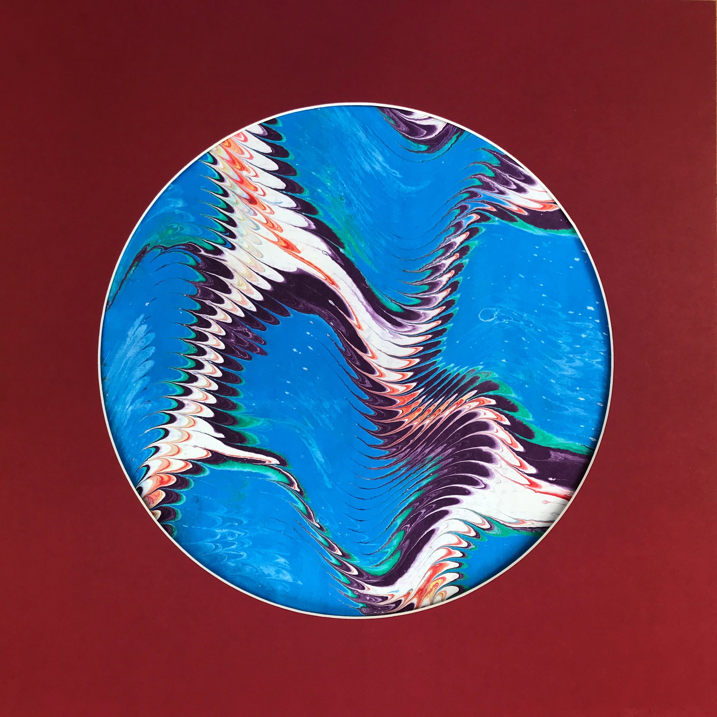 Blue Valley Marbled Moon print, a circular disc of blue marbling with dark zigzag waves on deep red