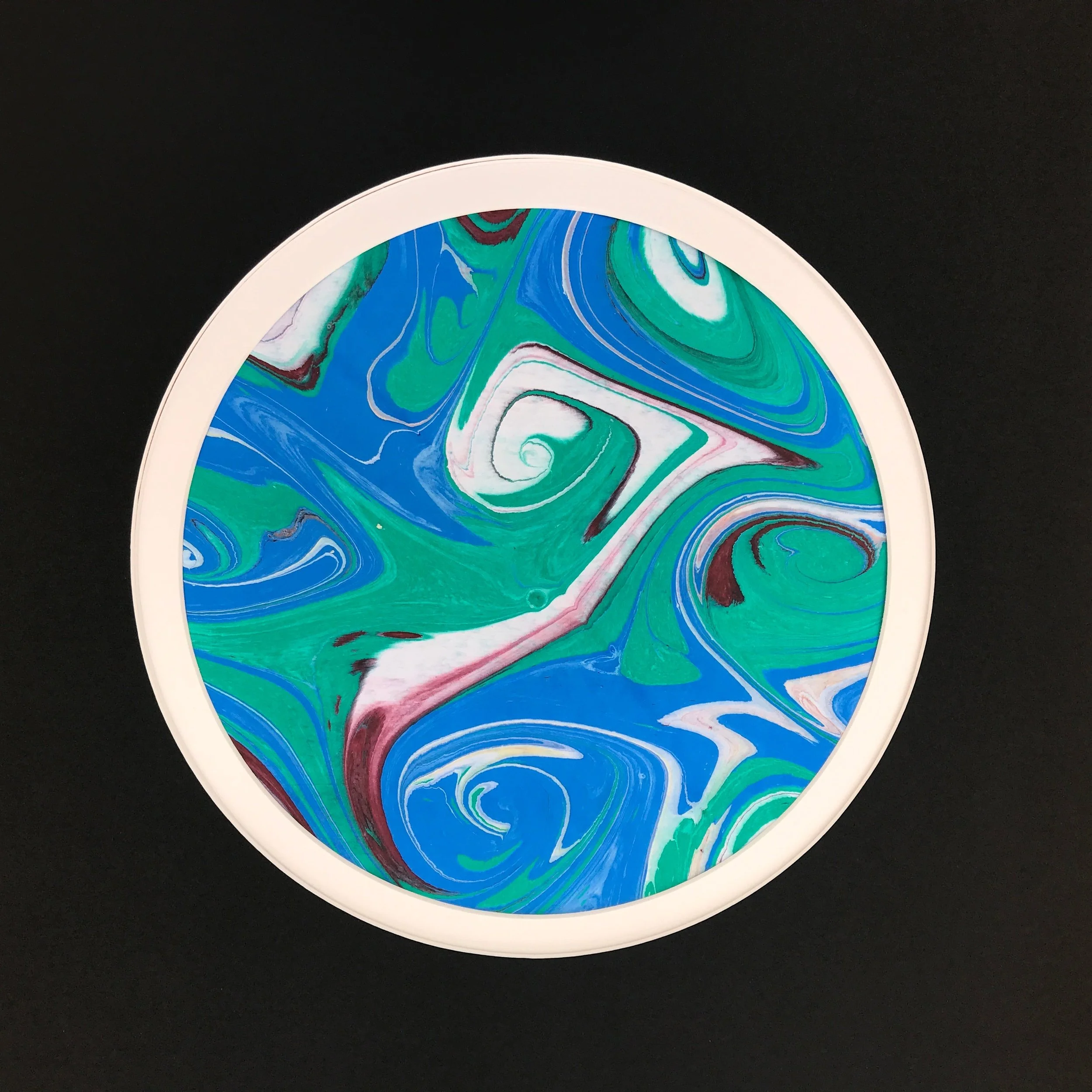 Green Marbled Moon print with a pale rim, the marbled swirls reading against a black ground