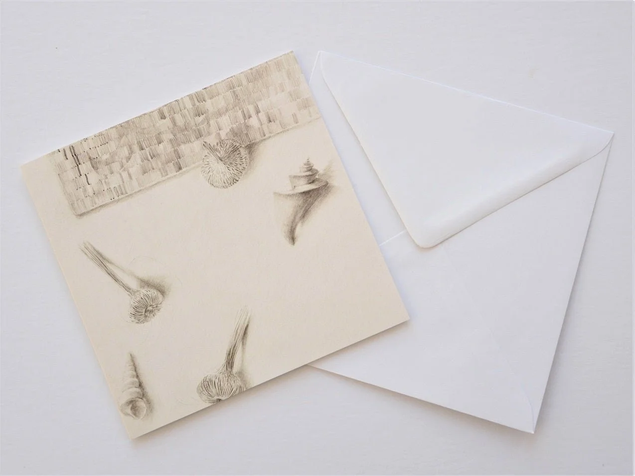 Woven Watsonia Shells greetings card shown at an angle with its white envelope