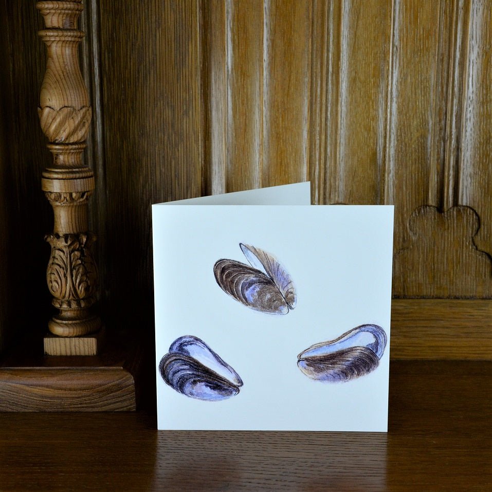 Mussel Mauves greetings card standing on a wooden mantelpiece