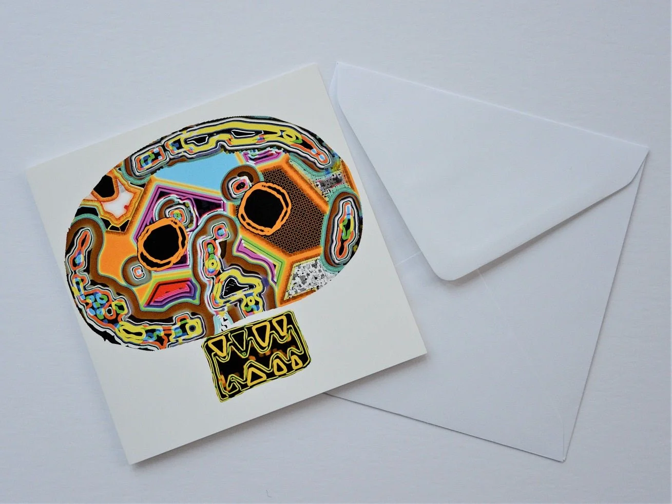 Untitled Mask greetings card shown at an angle with its white envelope