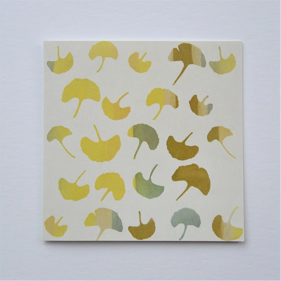 Ginkgo Autumn greetings card, a scattered pattern of yellow and green ginkgo leaves on cream