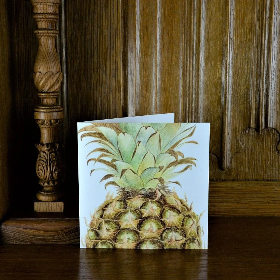 Pineapple Portrait greetings card standing on a wooden mantelpiece