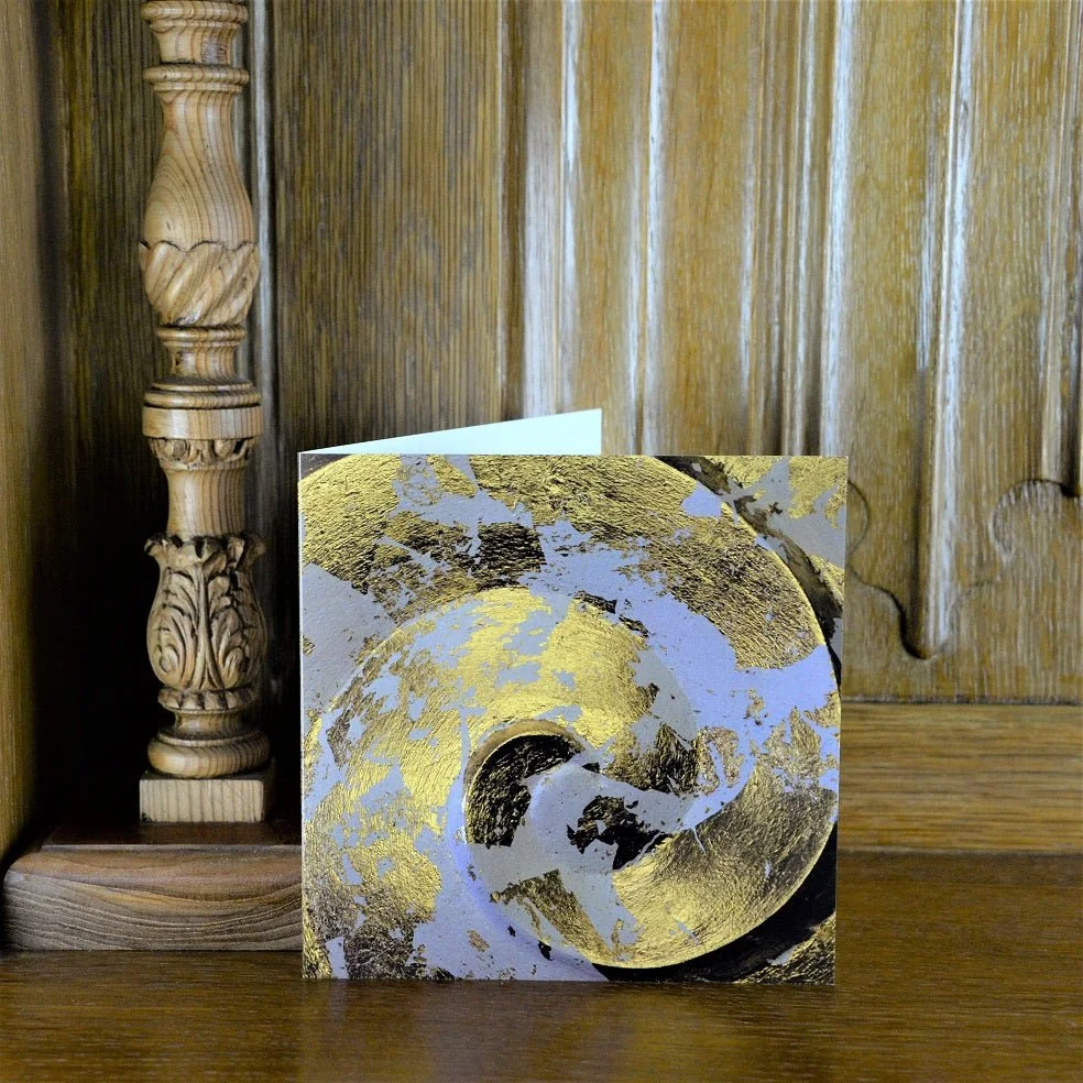 Golden Spiral greetings card standing on a wooden mantelpiece