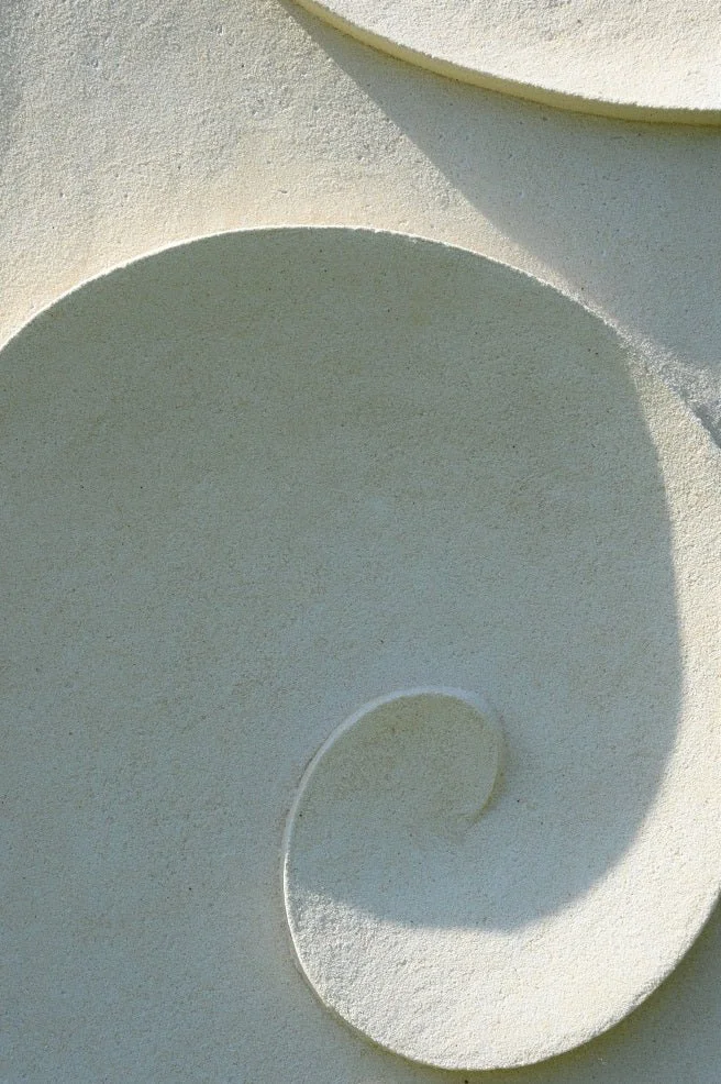 Close view of the Moonwave wall sculpture showing the smooth curl of the carved wave