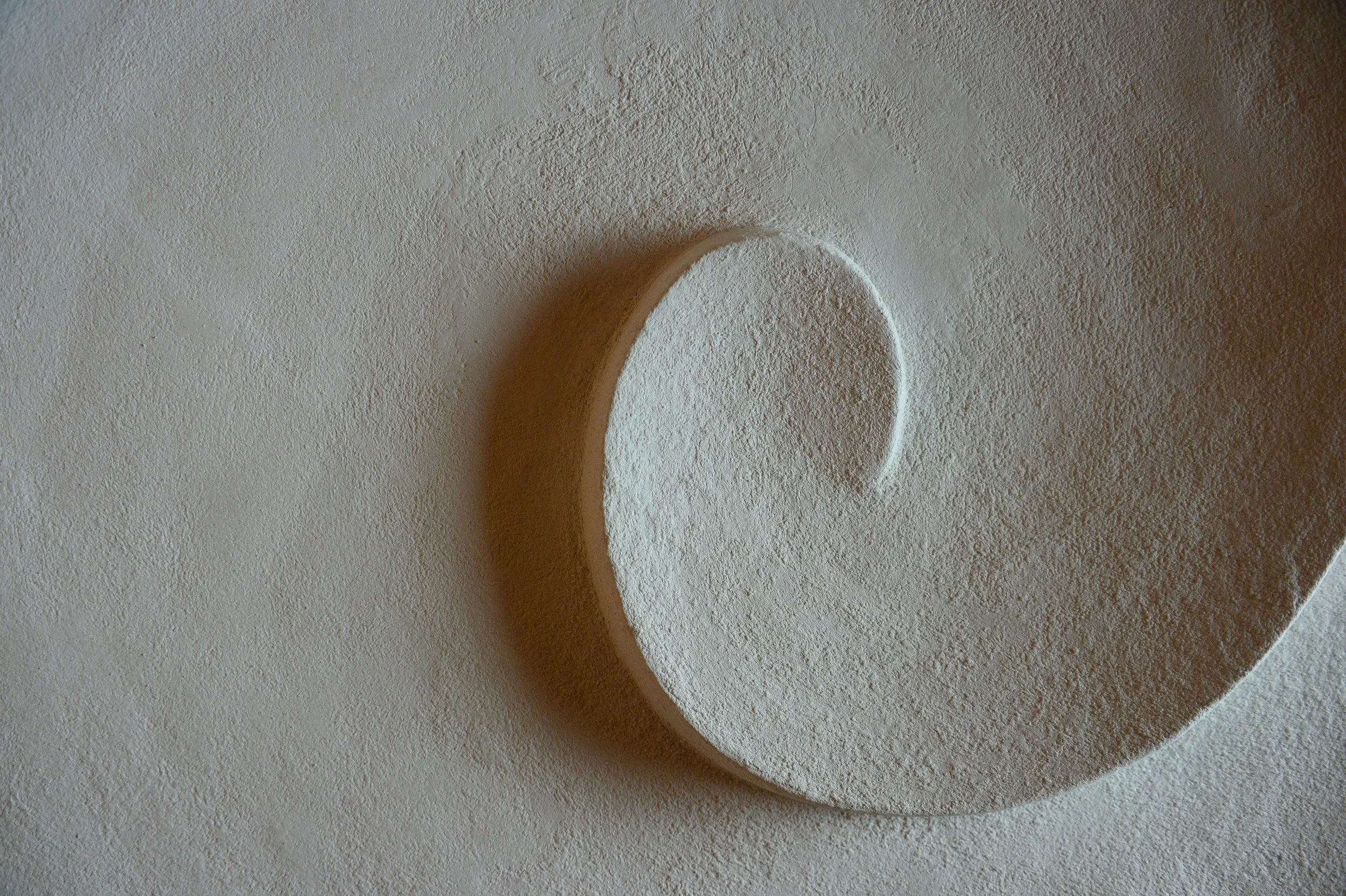 Close detail of the Moonwave wall sculpture, the carved crescent curling across the panel