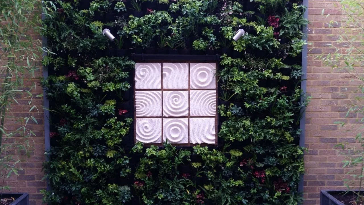 Japanese Raked Water Path four-part wall sculpture mounted on an ivy-covered garden wall