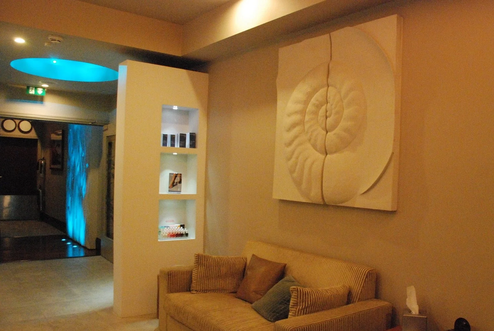 Ancient Ammonite wall sculpture on the wall of a salon reception area above a sofa